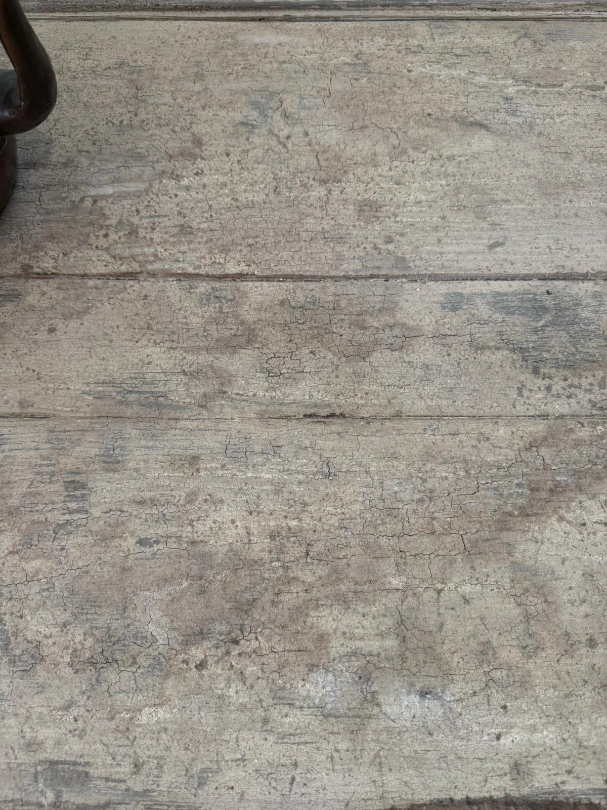 Superficie di legno chiaro, con evidenti screpolature e segni di usura.