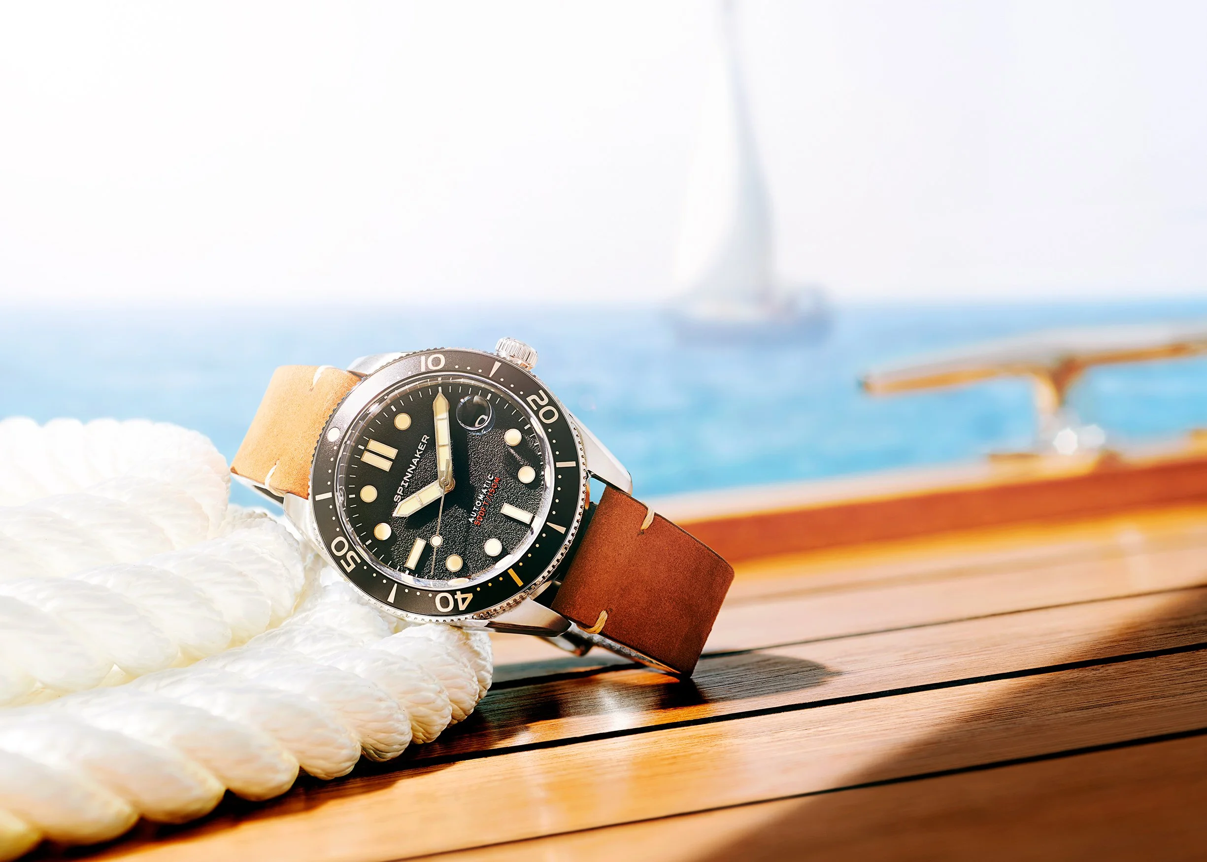Spinniker Croft watch lying on the wooden deck of a yatch at sea next to rope pile
