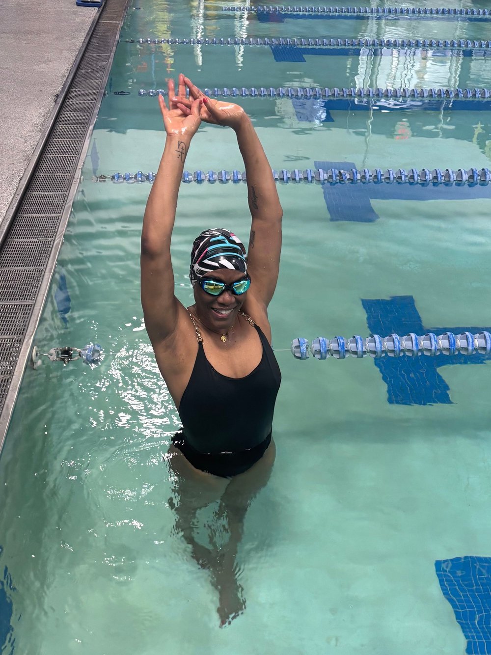 Happy swimmer raising her arms in the lane during a stroke development lesson