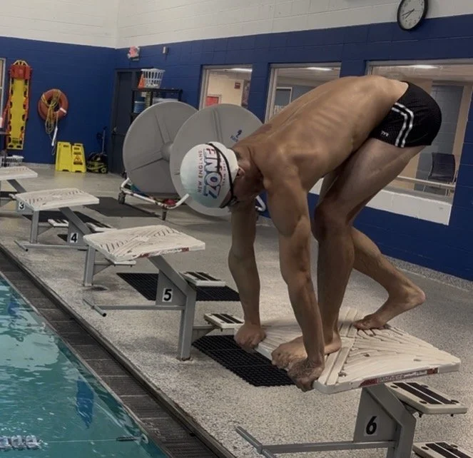 Competitive swimmer on the starting block ready to dive