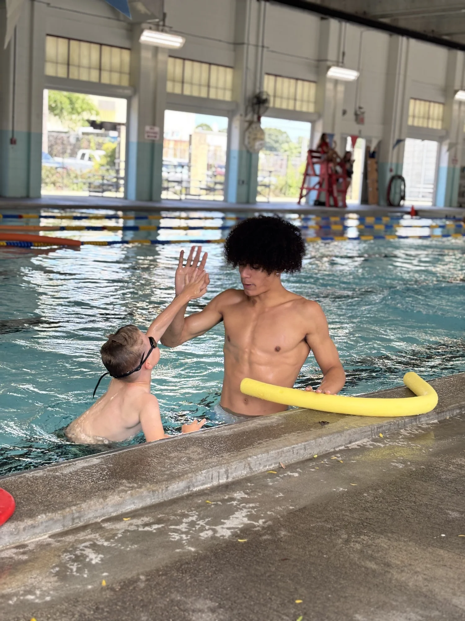 Coach Avery teaching a young swimmer