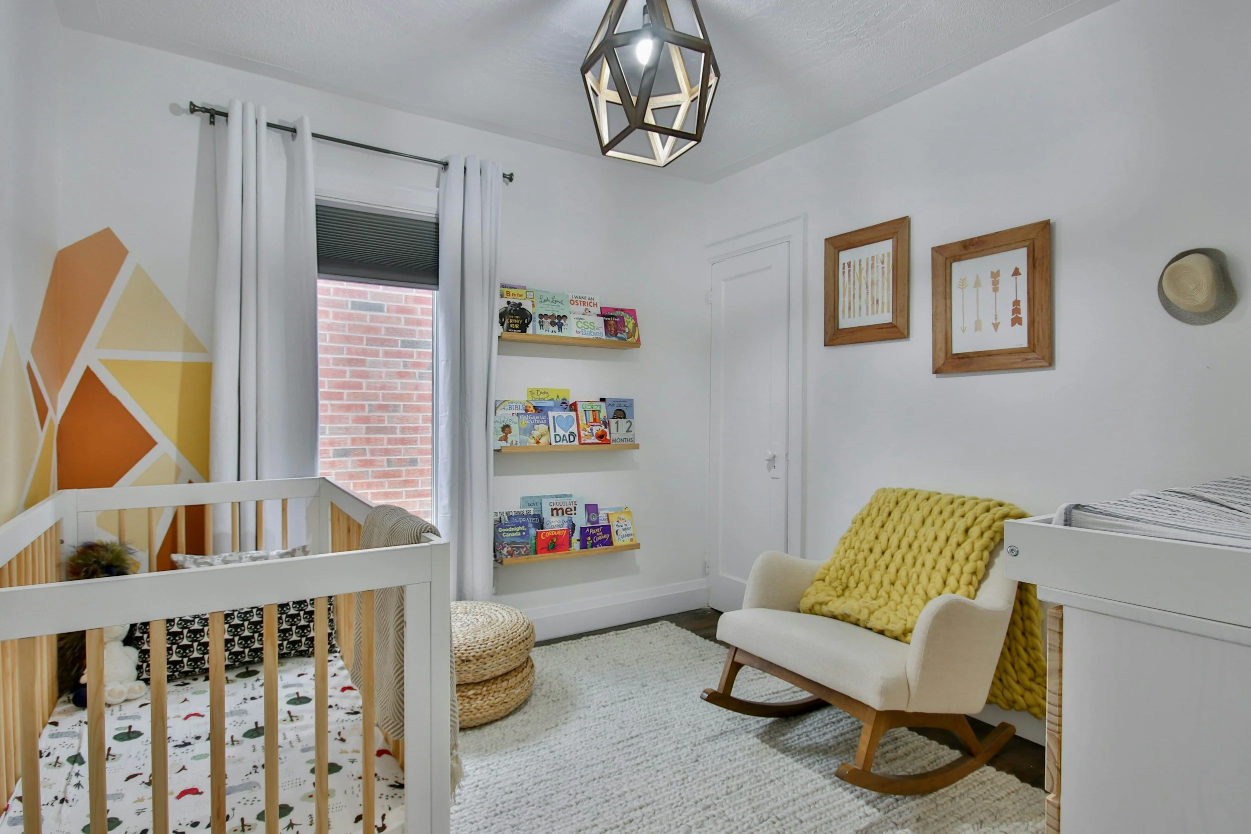 Neutral boho nursery with crib, rocking chair, and children's books