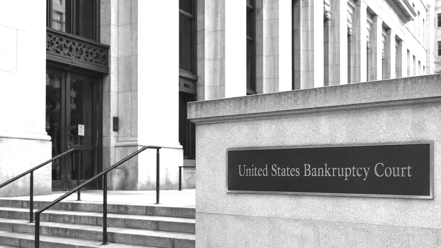 Black and white photo of the United States Bankruptcy Court building, with stairs, railing, and a sign indicating the court's name.