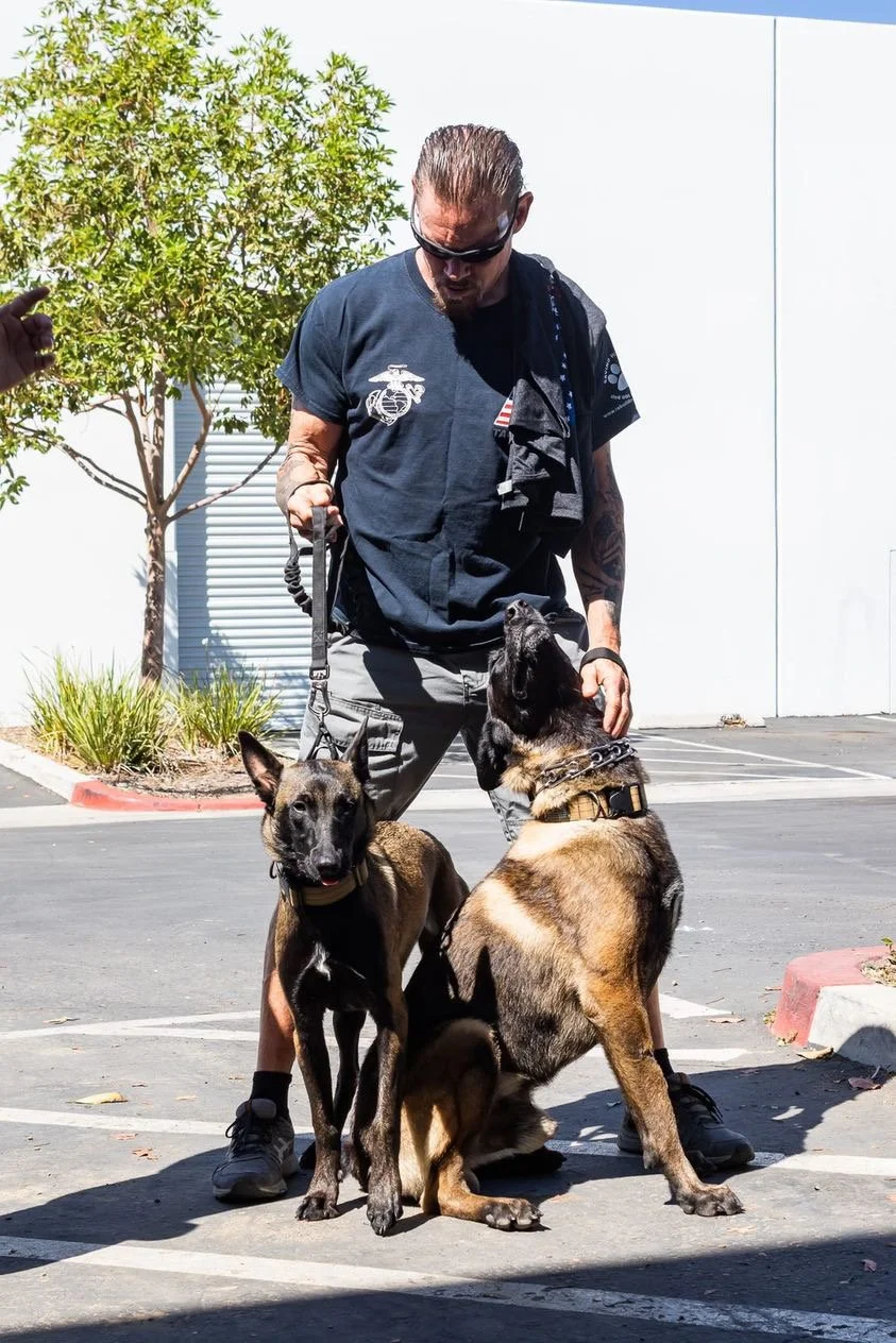 Geoff Meed with his Belgian Malinois, Arya and Onyx, reflecting his active lifestyle and lifelong commitment to health, fitness, and the outdoors.