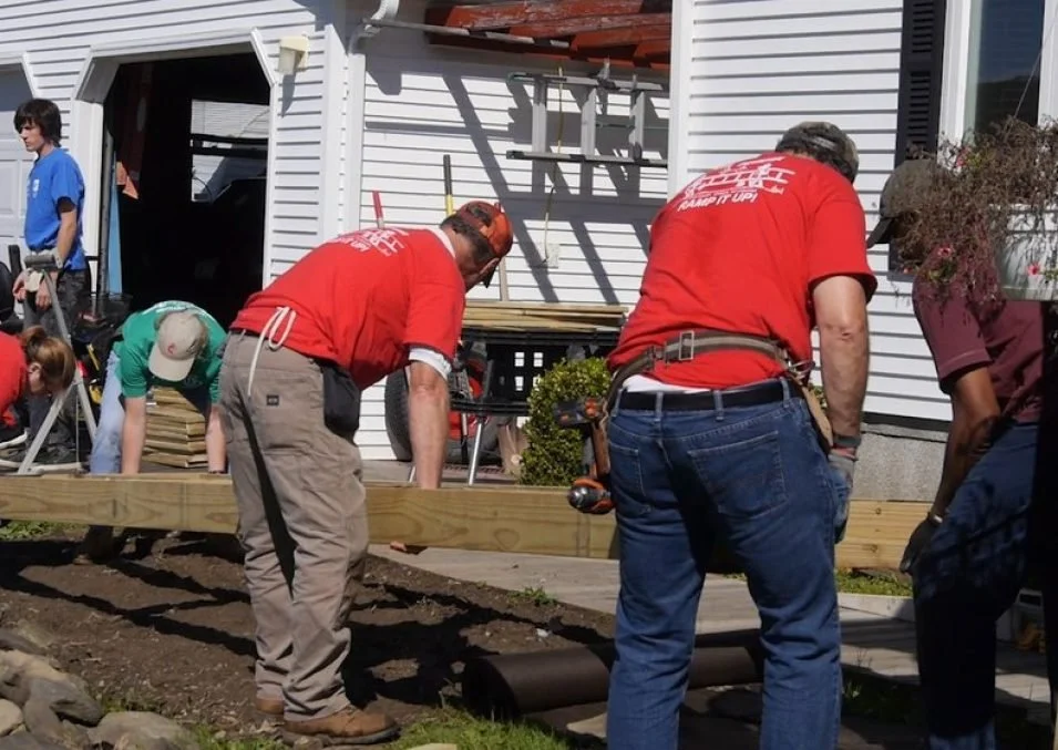 People working on a home improvement project outside a house.