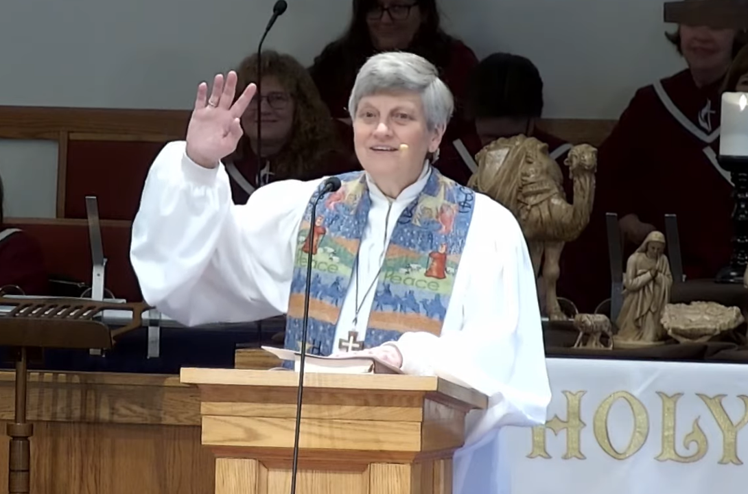 Sr. Pastor leading a church service, with nativity figurines in the background.
