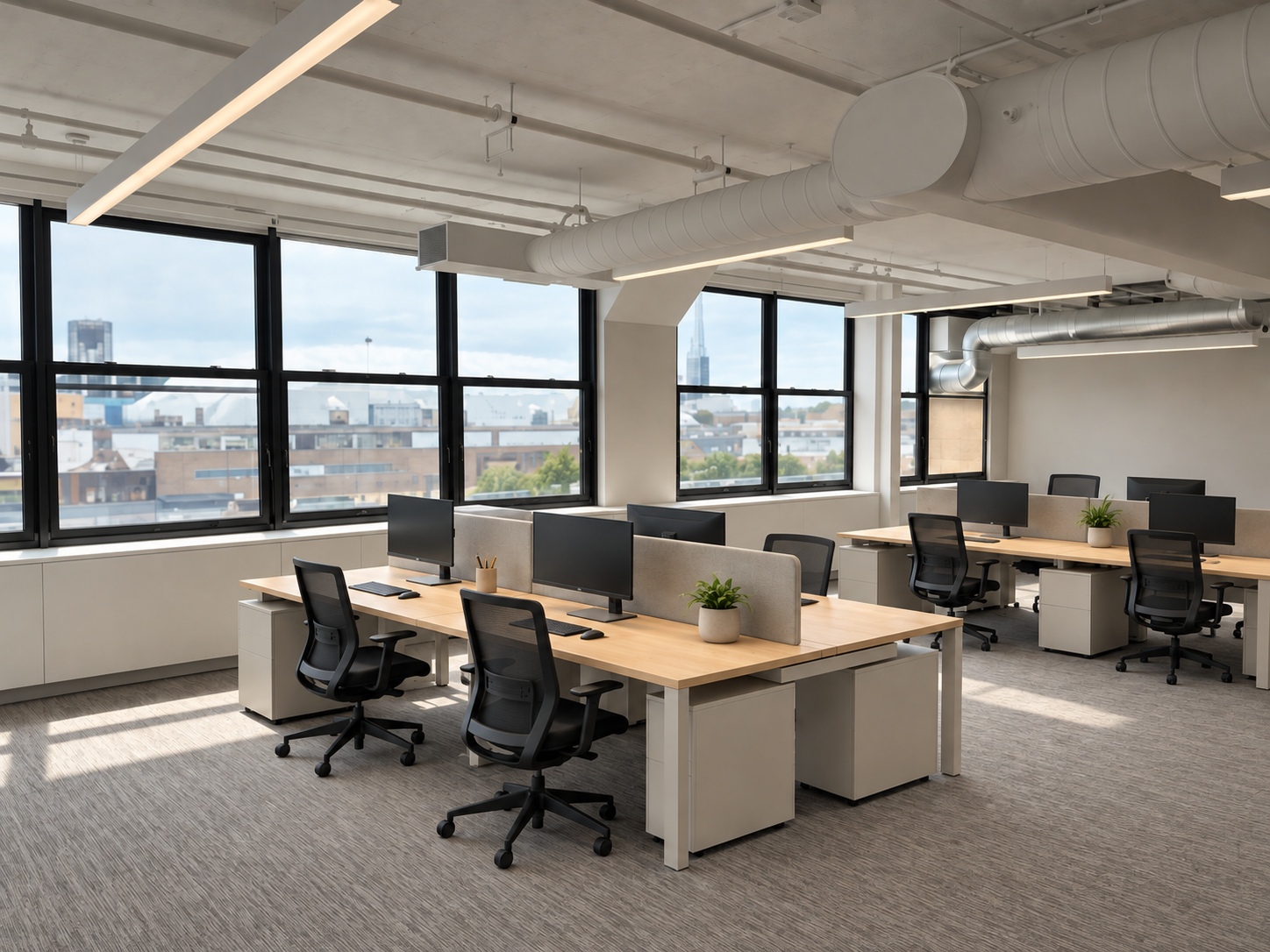 Modern New York City workplace interior with open office workstations, large windows, and exposed ceiling details.