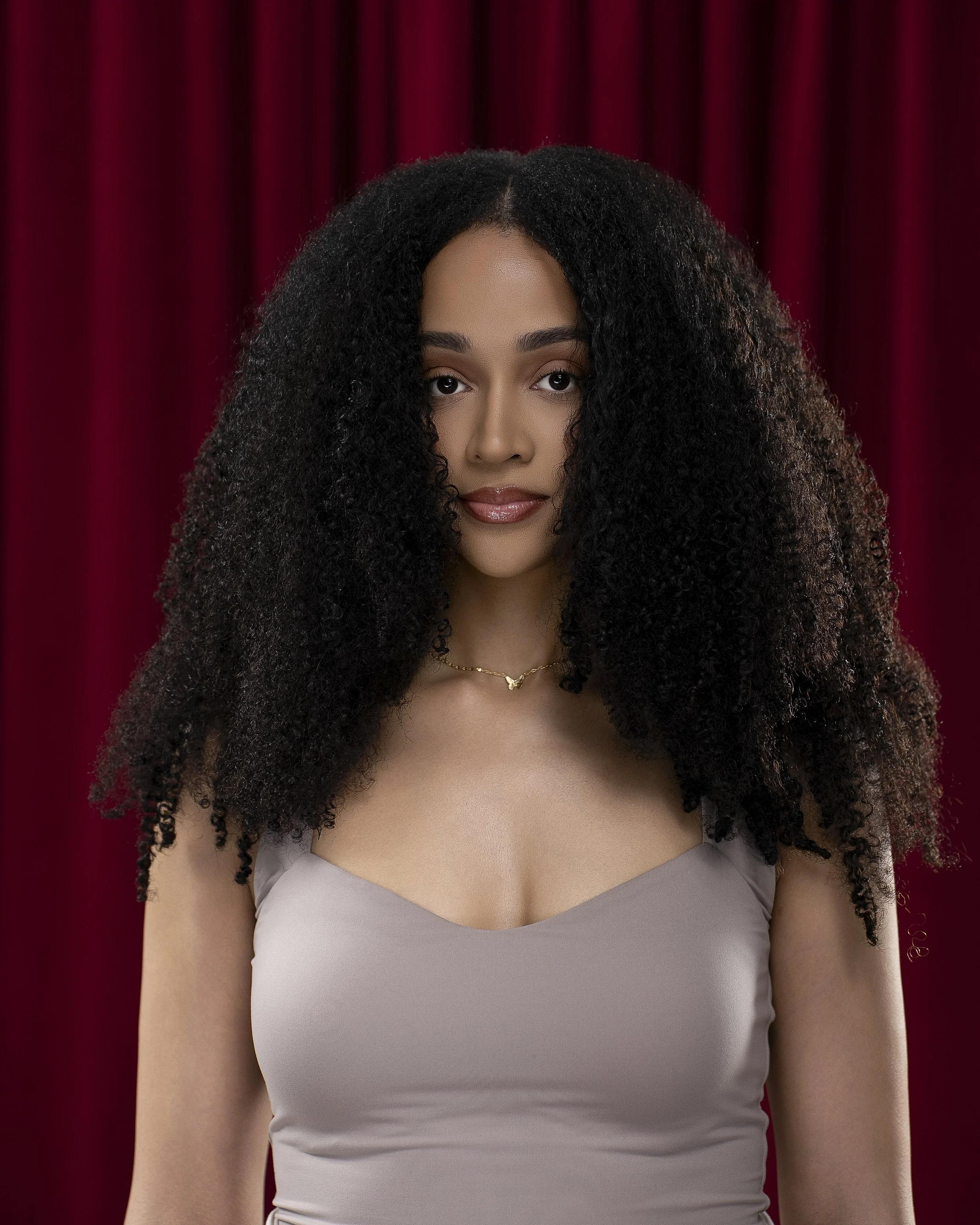 Close-up portrait of Black woman, Love Luxury client wearing raw afro curly black hair bundles, Kansas City.