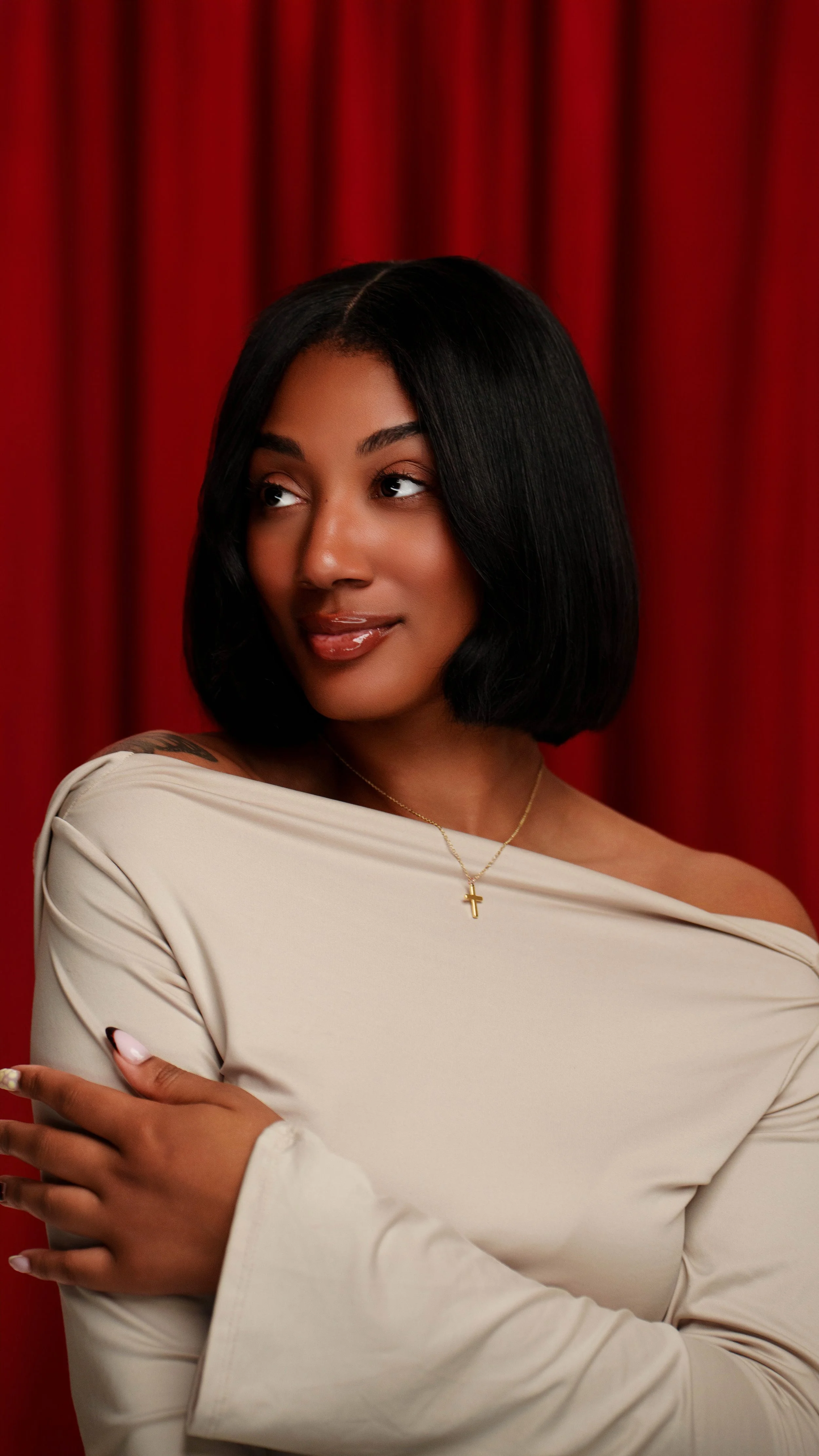 Imani Love, founder of Love Luxury, wearing a straight black bob with raw hair and cream off-the-shoulder top, Kansas City natural hair stylist.