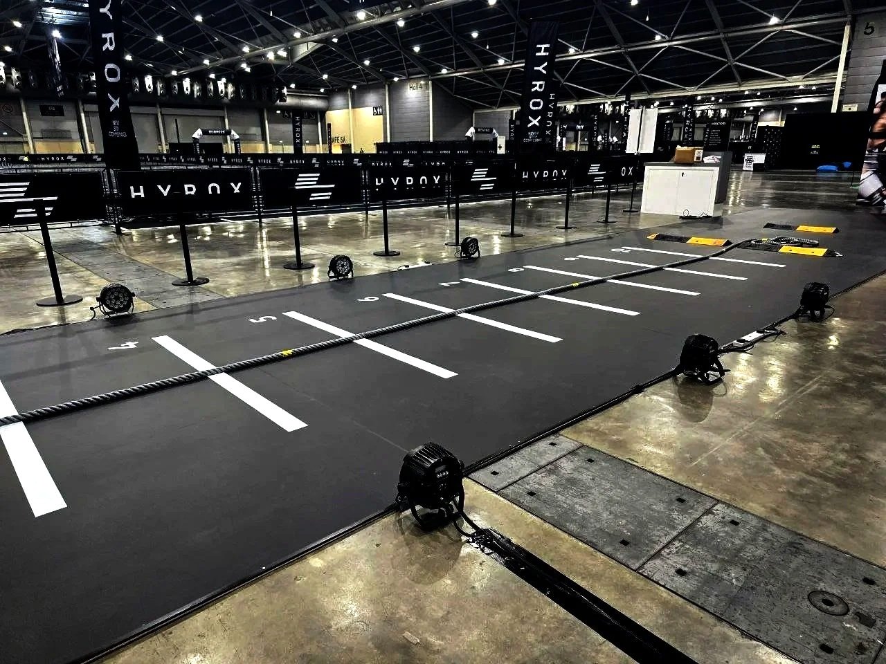 Indoor event space with numbered parking spots, barriers, and stage lighting setup for a HyperX gaming or e-sports event.