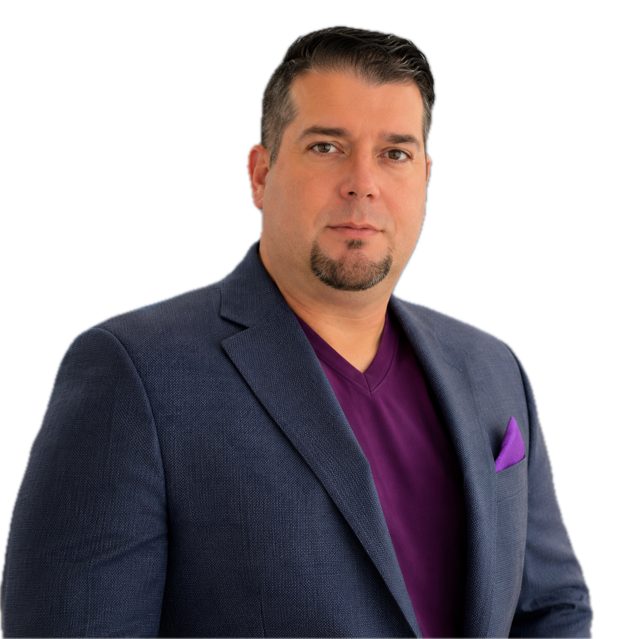A man in a dark blue blazer and purple V-neck shirt with a purple pocket square, facing the camera.