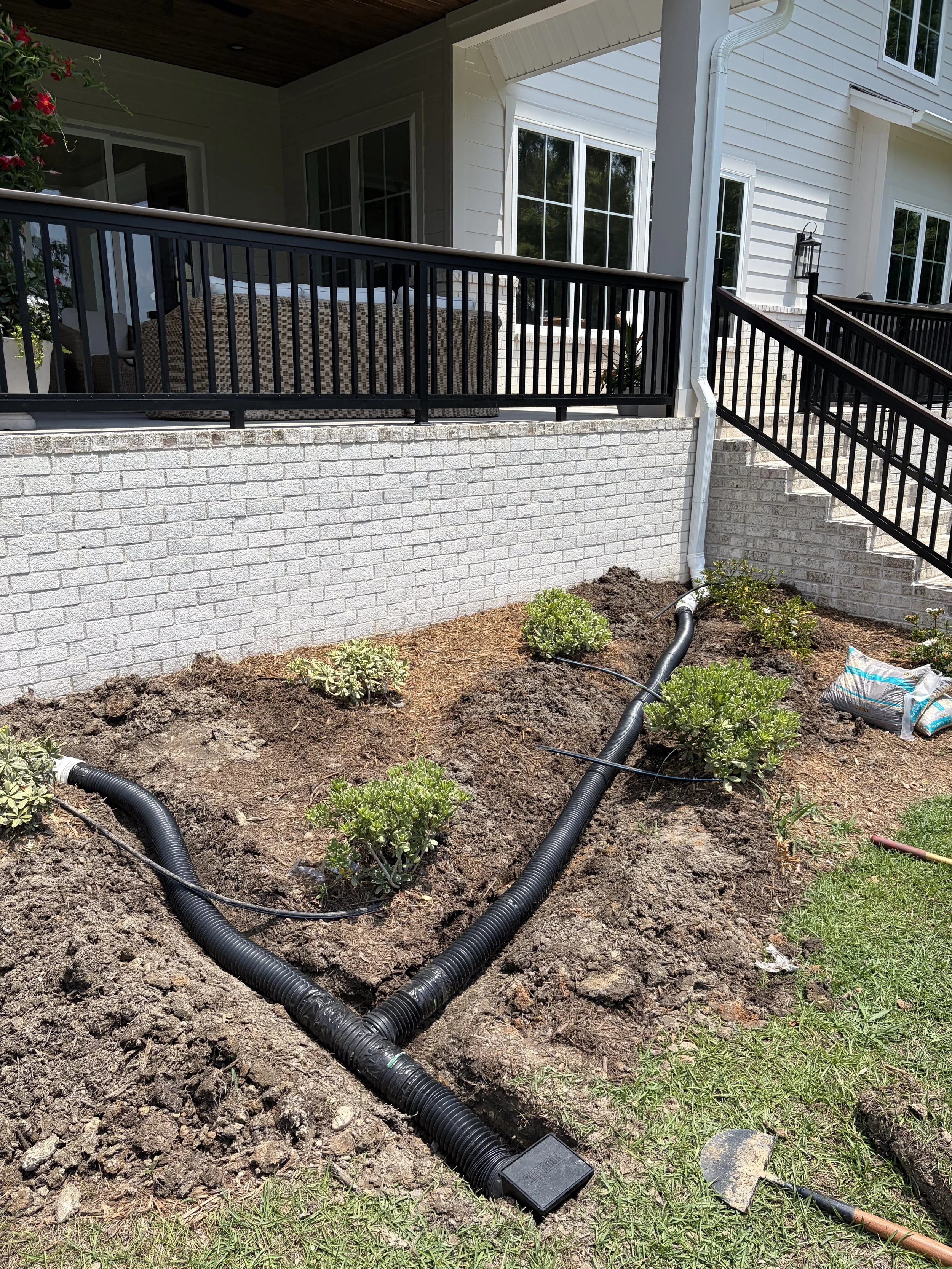 Adding pop up gutter drain to prevent mulch from washing out.
