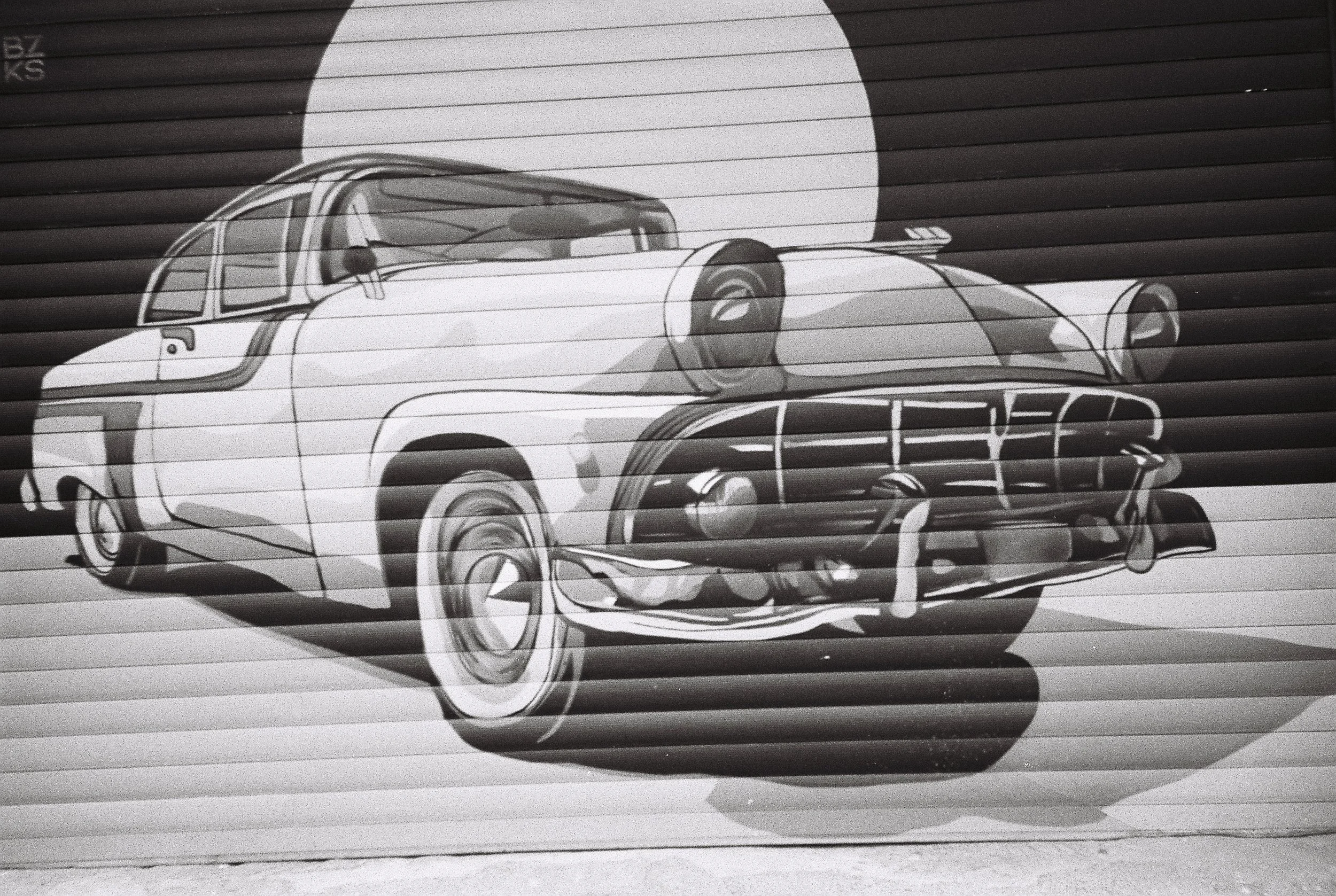 A black and white drawing of a futuristic sports car with sleek curves and a low profile, overlaid on a background of horizontal lines.