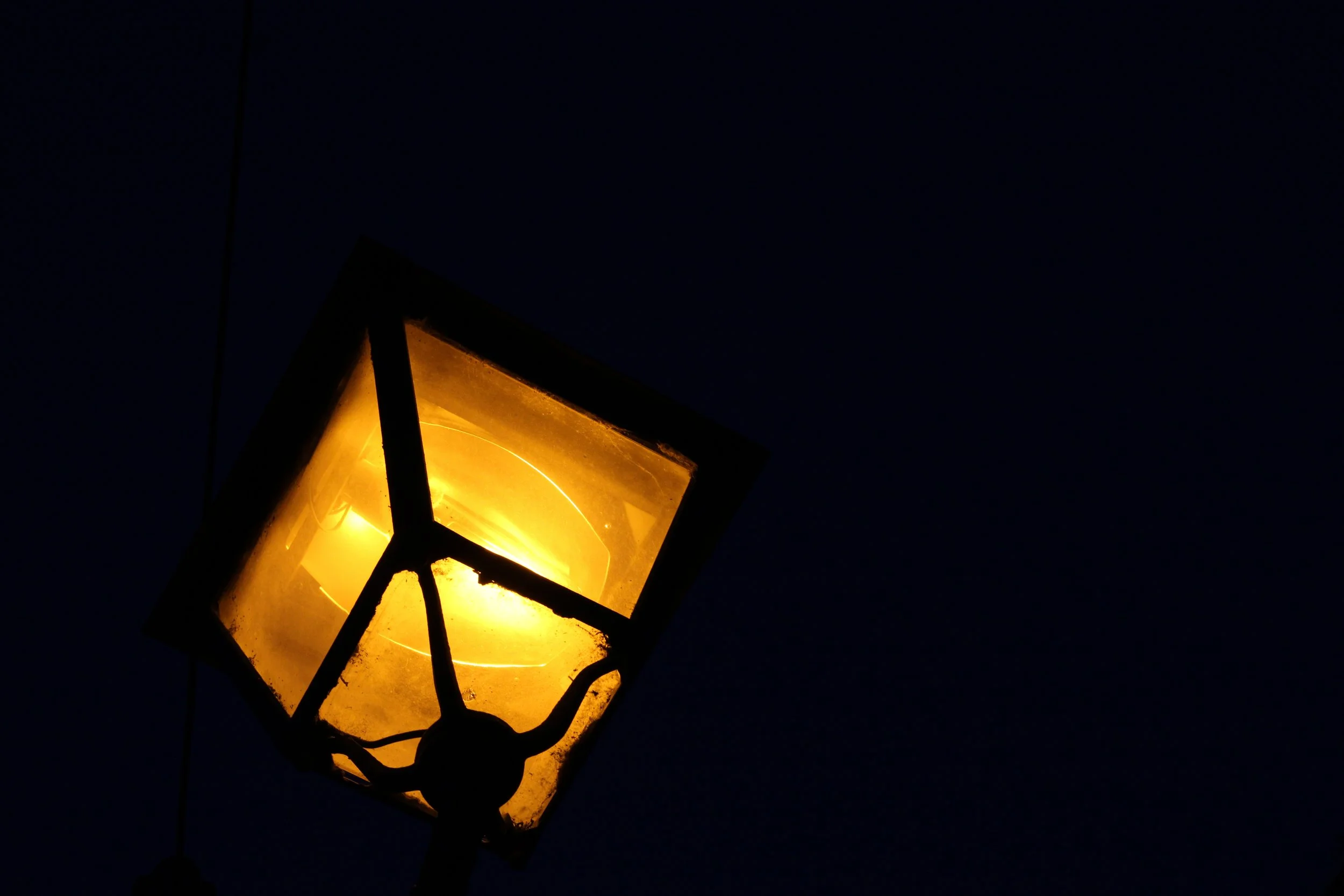 A lit street lantern against a dark night sky.