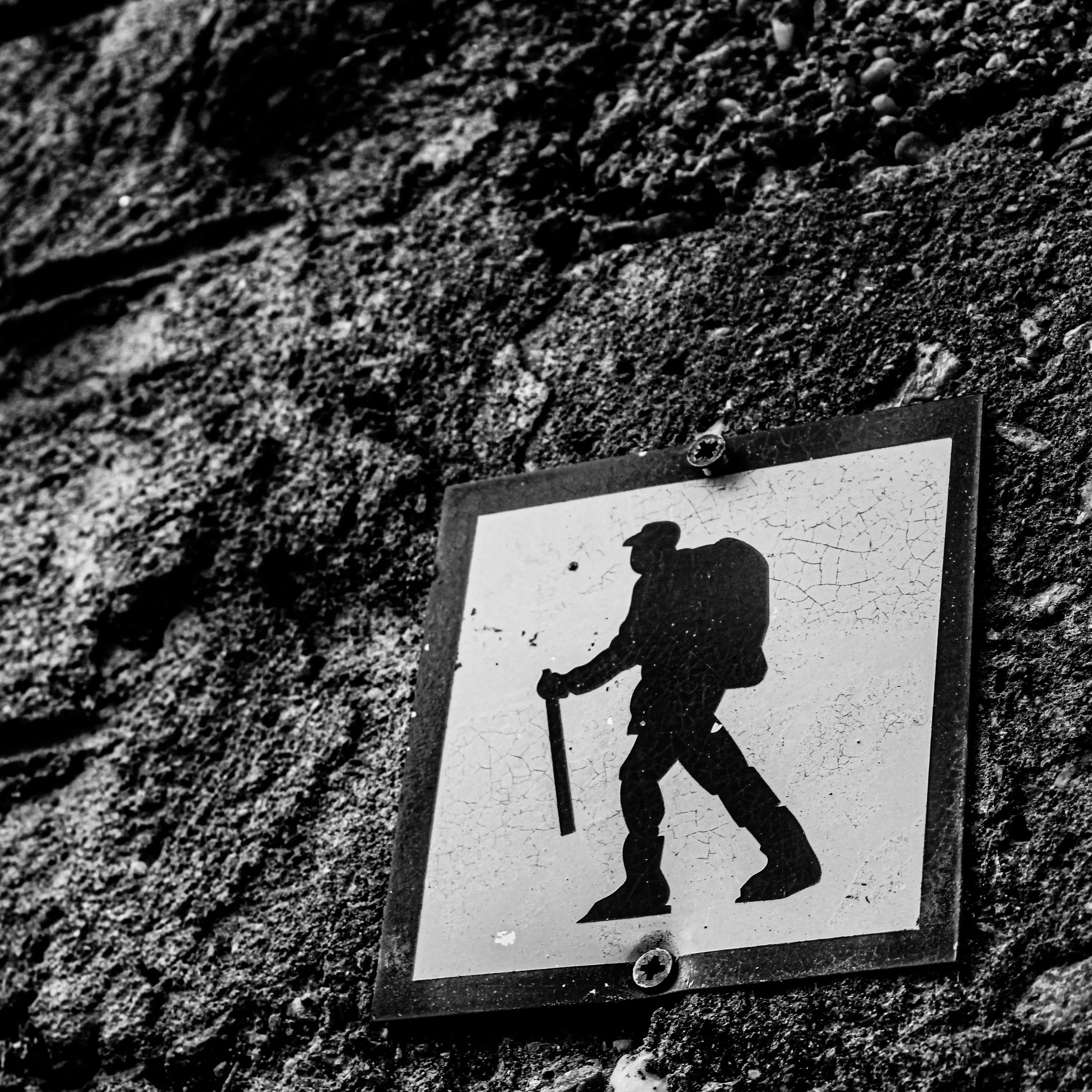 Close-up of a dirt or gravel surface with a partially visible railroad crossing sign or sticker showing a silhouette of a dog