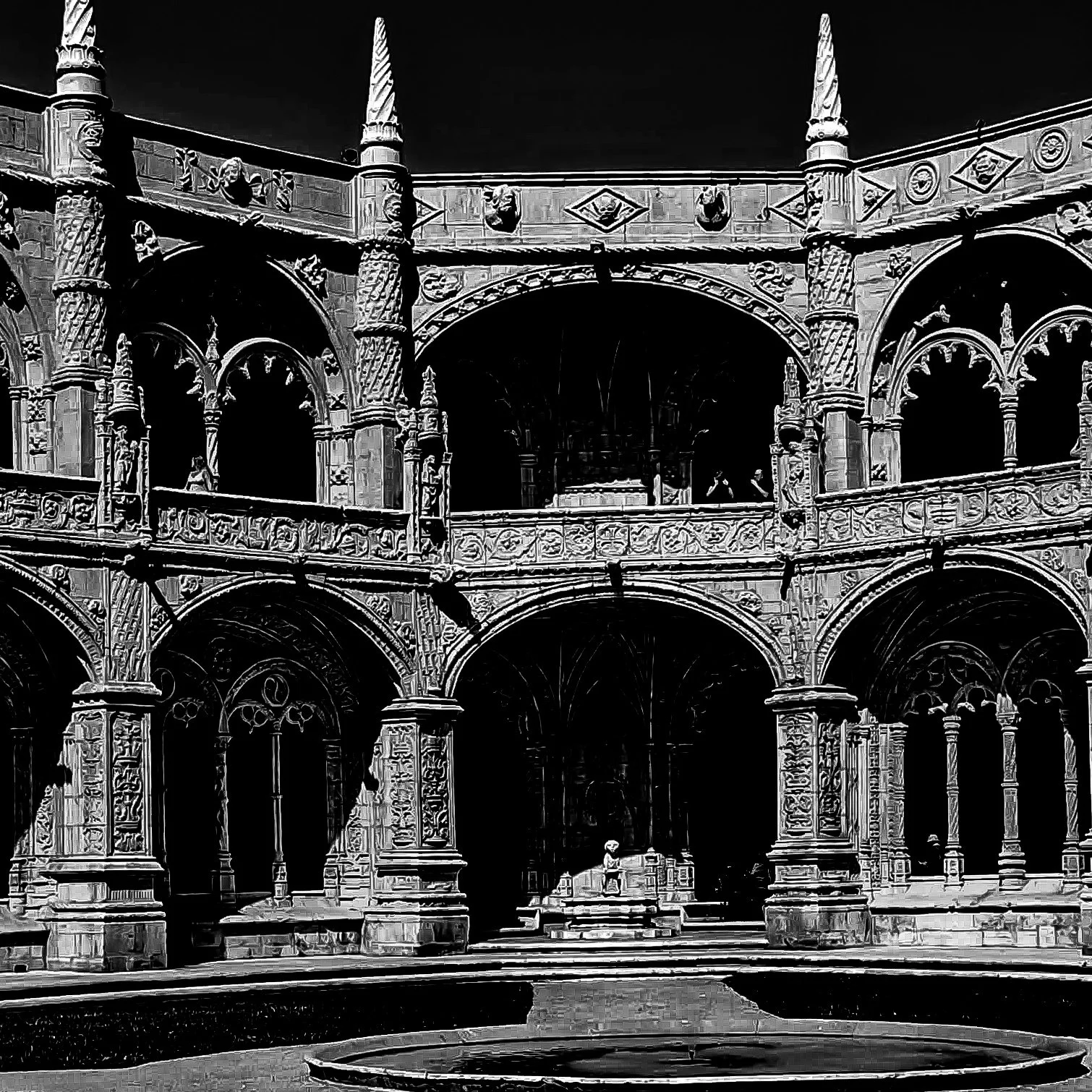 Historical building with ornate architecture, arches, and columns, showing detailed carvings and decorative elements in black and white.