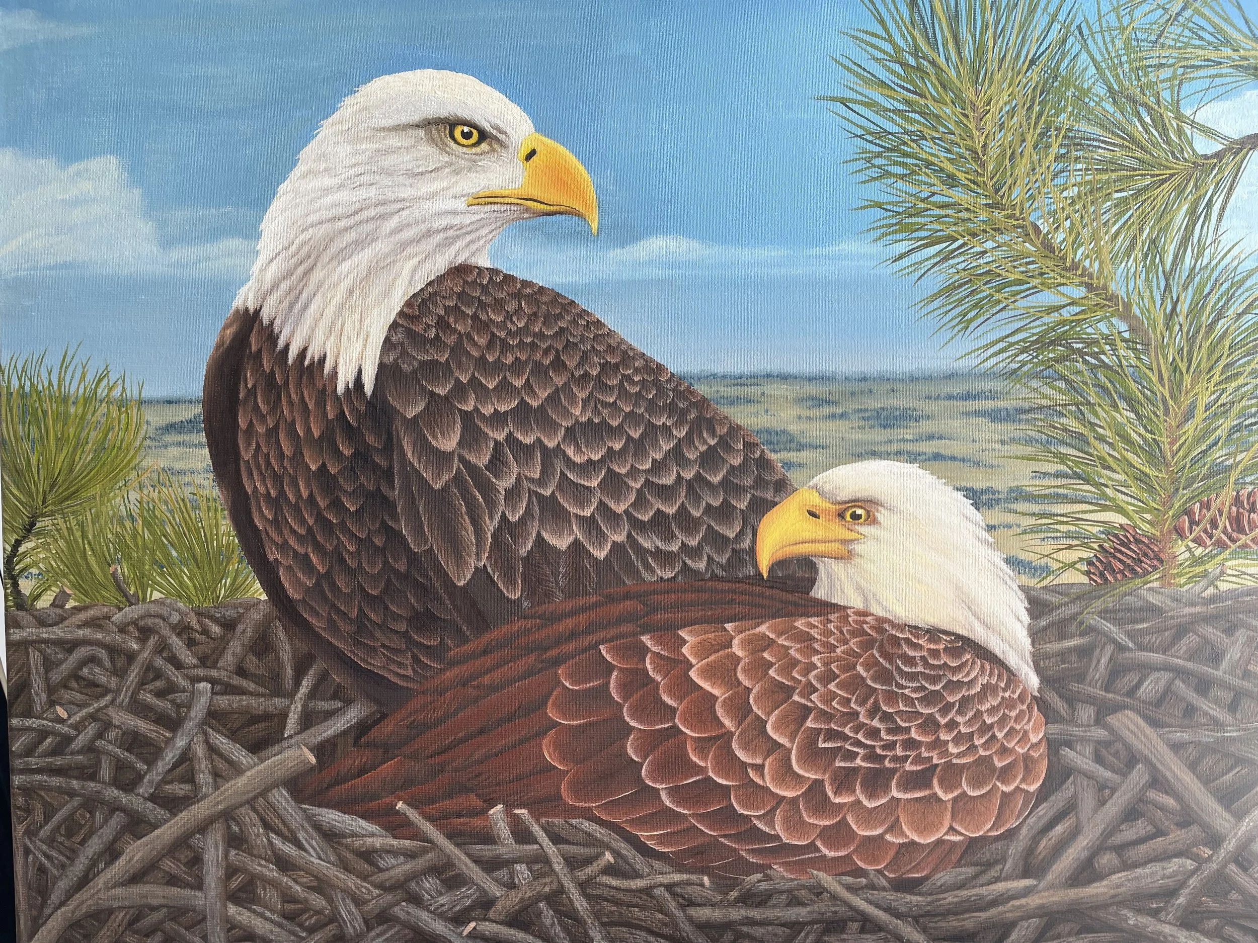 Painting of two bald eagles perched on a nest with a distant landscape, blue sky, and some clouds in the background.