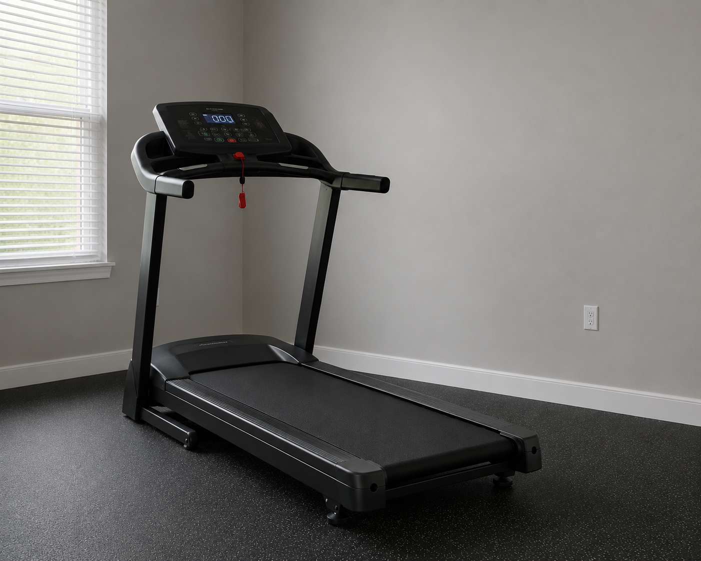 Black treadmill in a room with gray walls, a window with white blinds, and a power outlet.