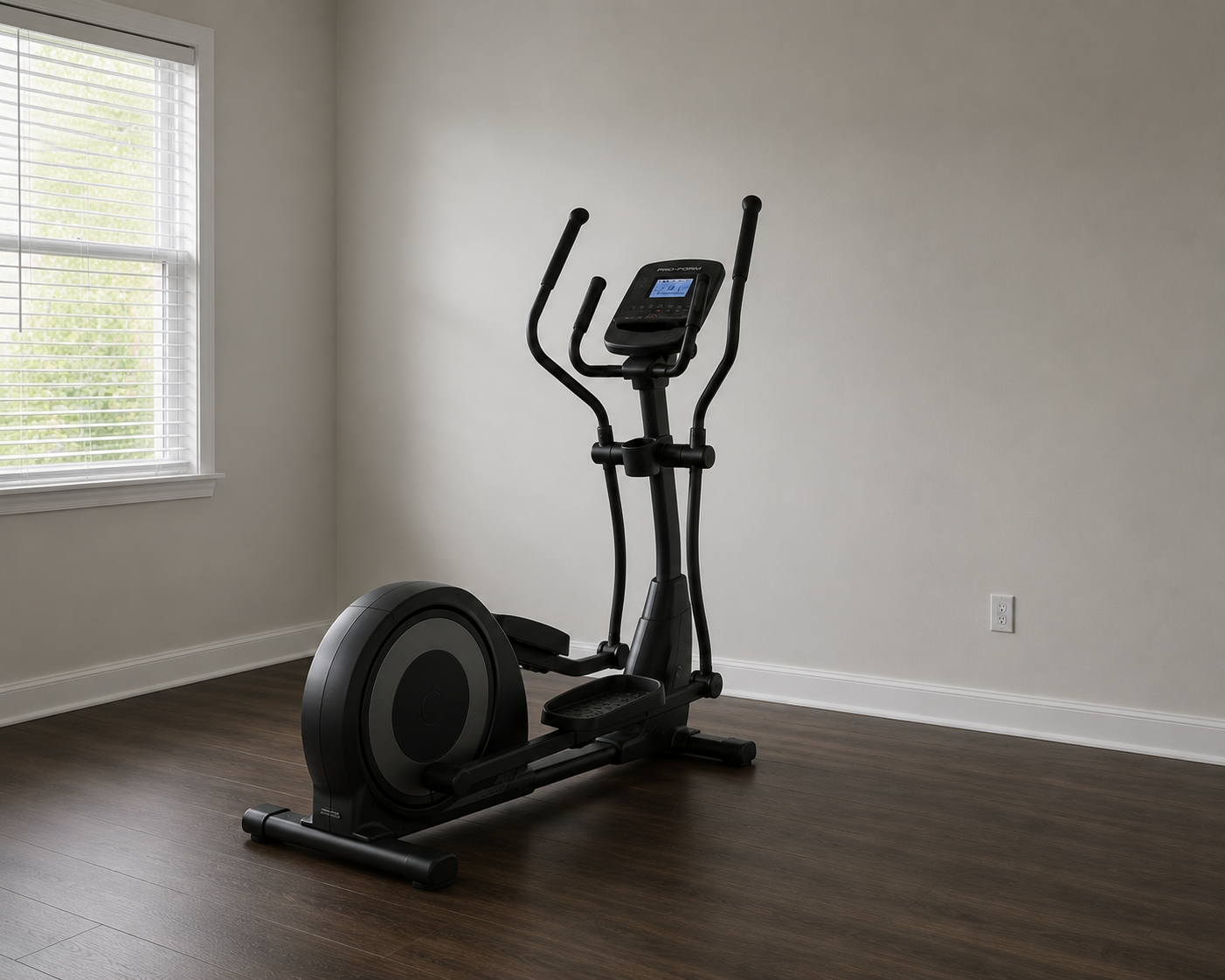 An elliptical exercise machine in a minimalistic room with wood flooring, white walls, and a window with blinds.