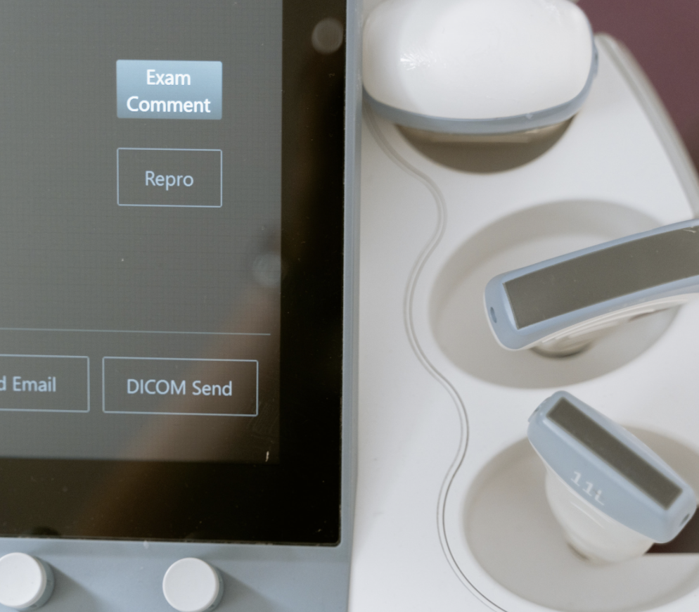 Close-up of a medical touchscreen device and three ultrasound transducers with wires.