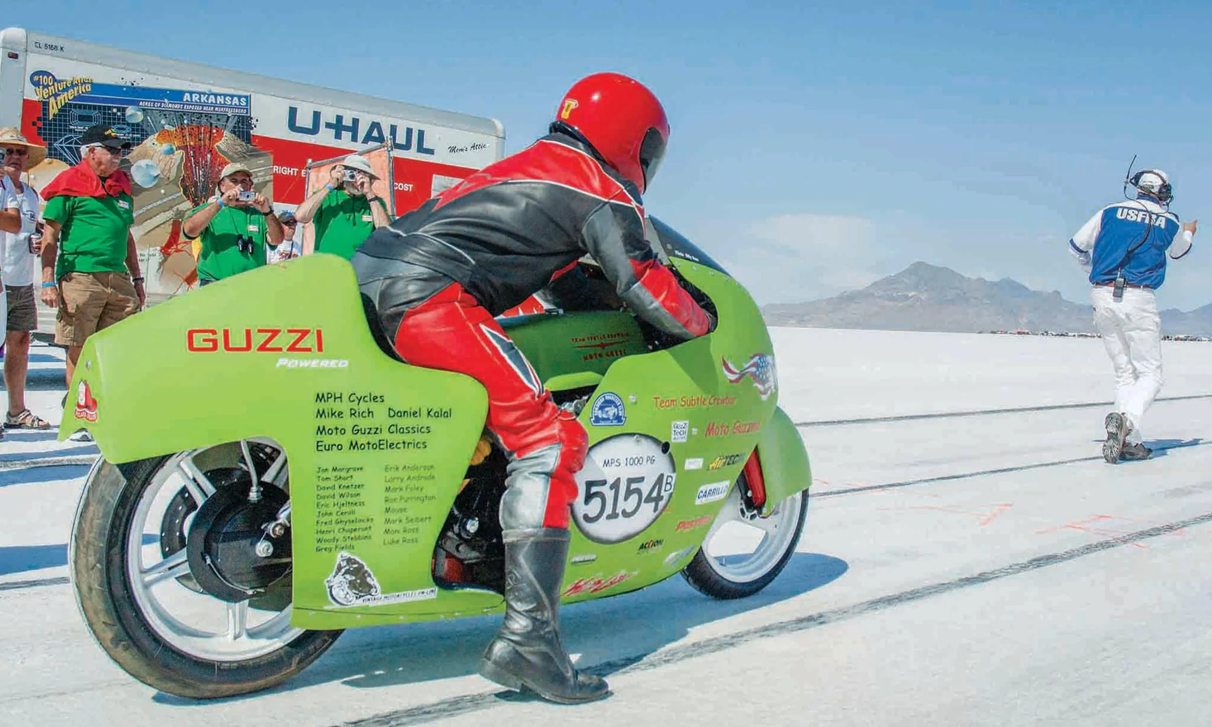 Bonneville racer, bright green Moto-Guzzi, at launch, rider in red black leathers 