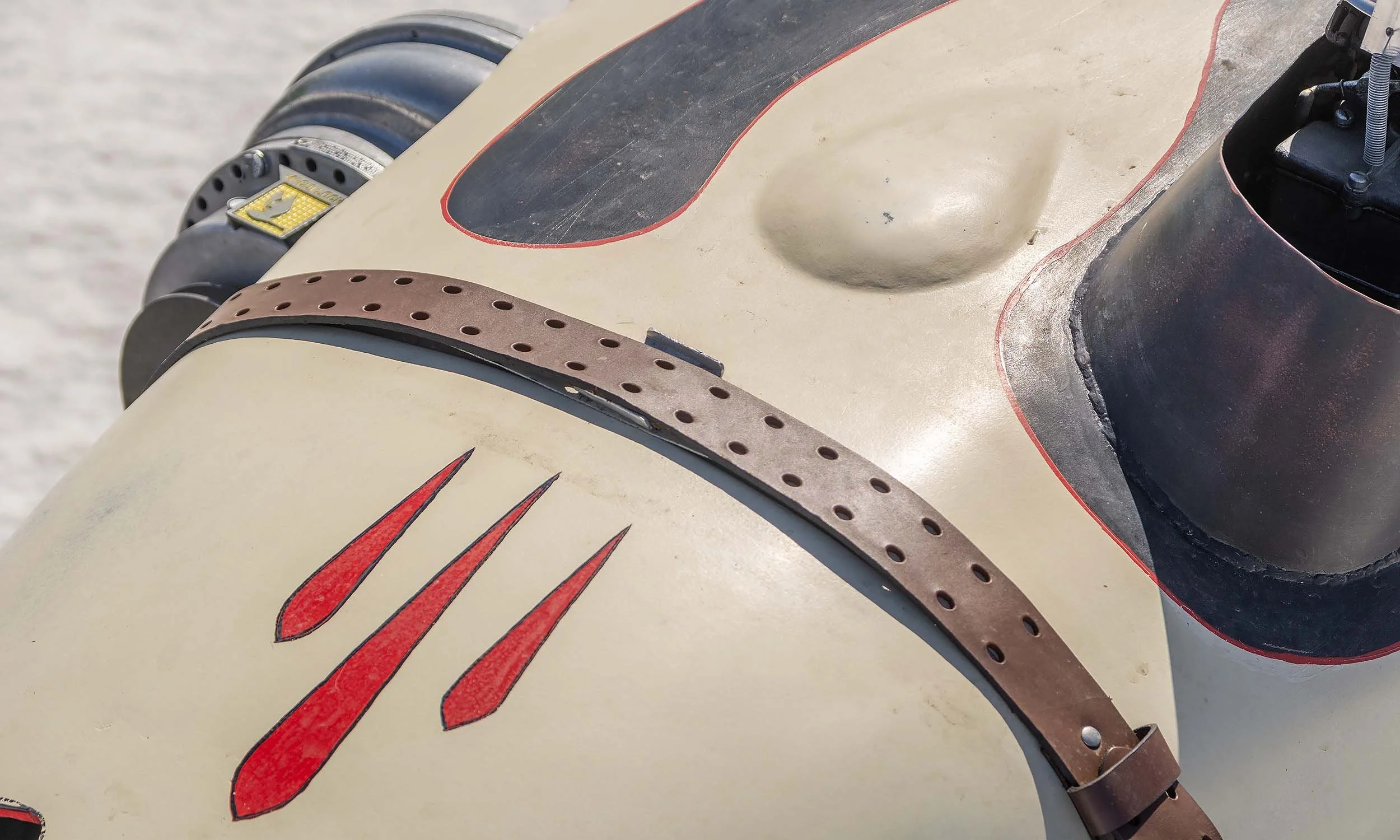 Close-up of a roadster's machine's surface, featuring three red scoring targets and part of the bumper area with metal and plastic components.