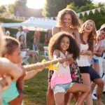 Children playing tug of war at an outdoor gathering or party.