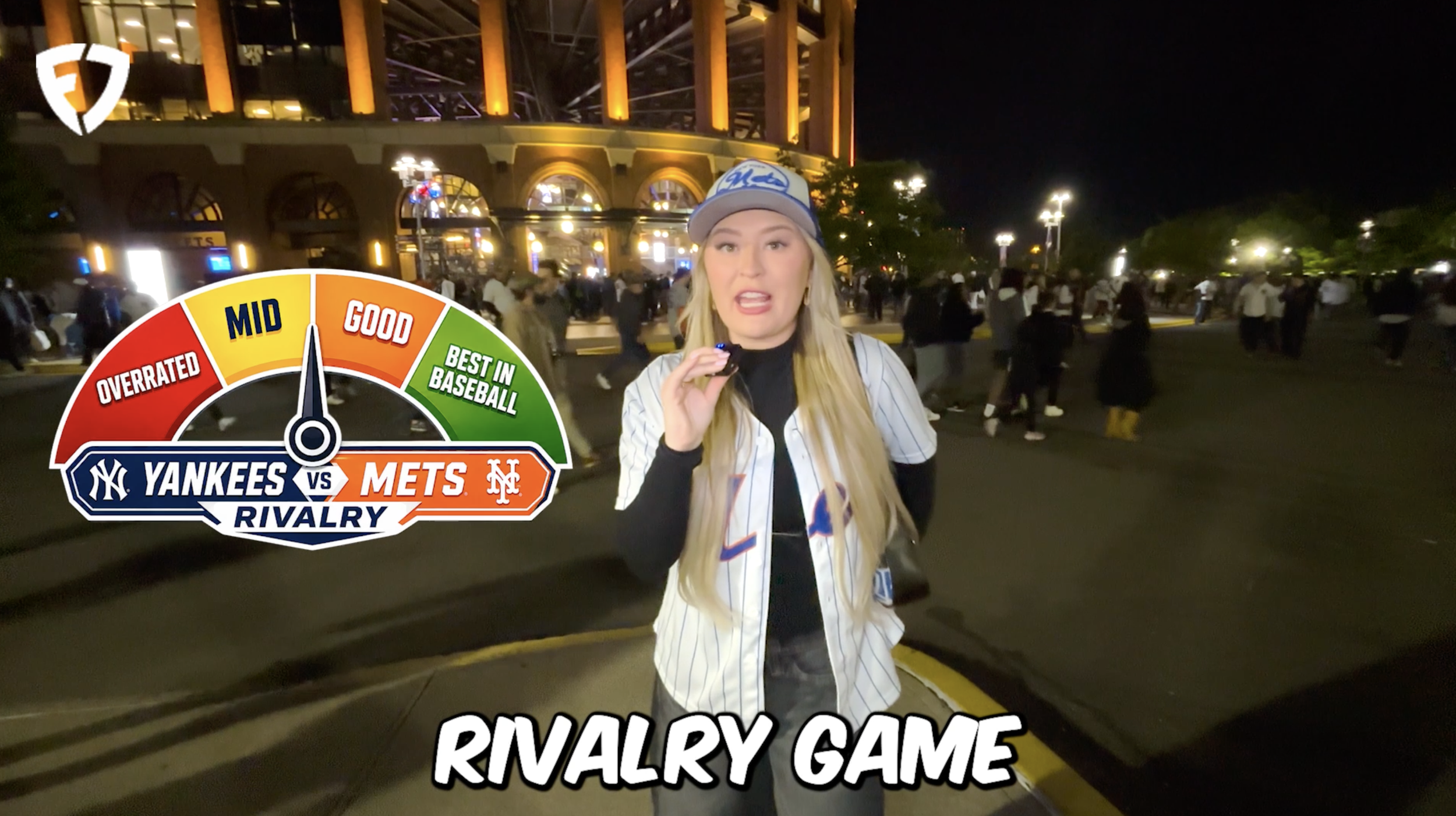 Nighttime outside a stadium with people walking by and a woman in a Yankees jersey and cap in the foreground, a graphic overlay showing a rivalry gauge between the Yankees and the Mets, and the text "RIVALRY GAME".