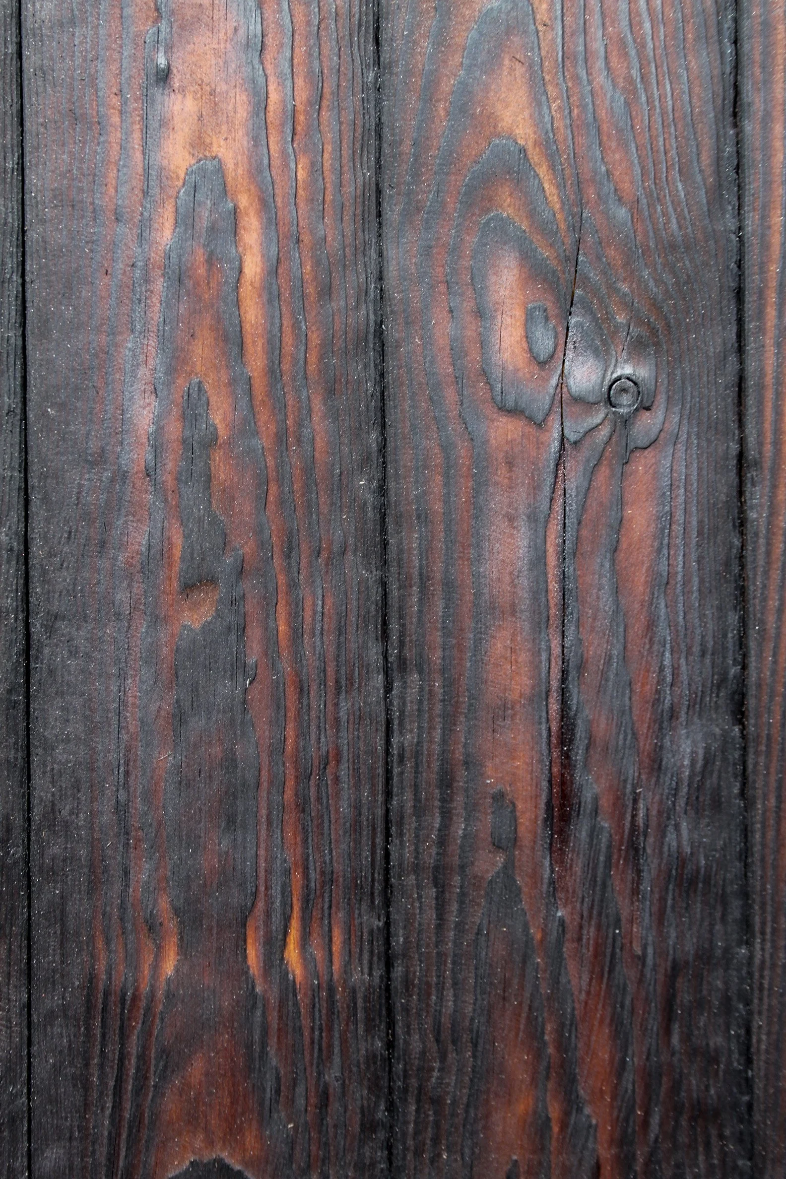 Holzplatte mit abgenutzer Oberfläche, sichtbar geöltes und verändertes Holz mit charakteristischen Maserungen und dunklen Linien.