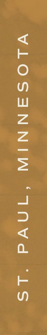 Close-up of a gold-colored object with the text 'PAUL, MINESOAI' printed vertically in white letters.