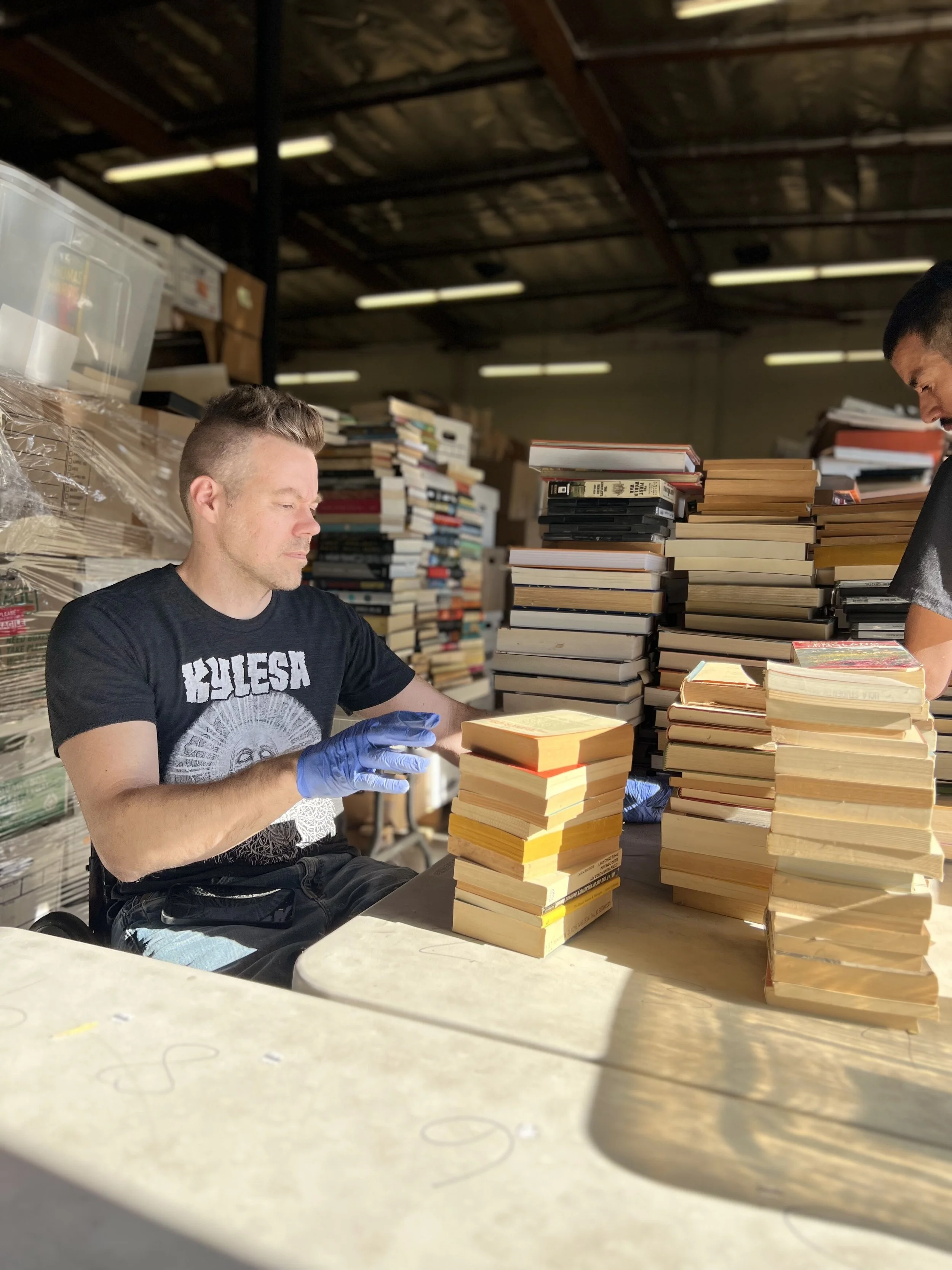 Volunteers sort donated books in the Save The Books warehouse before redistribution to schools, libraries, shelters, bookstores, hospitals, and community organizations.