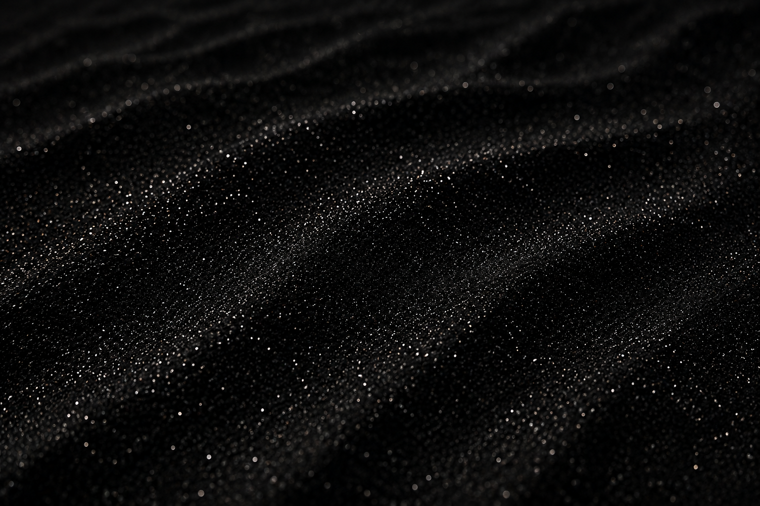 Close-up of black fabric with tiny shimmering particles creating a sparkling effect.
