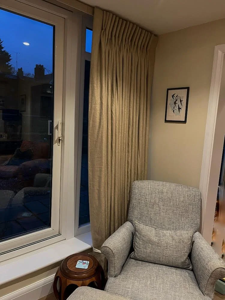 gold curtains on lathe and fascia track with blue chair