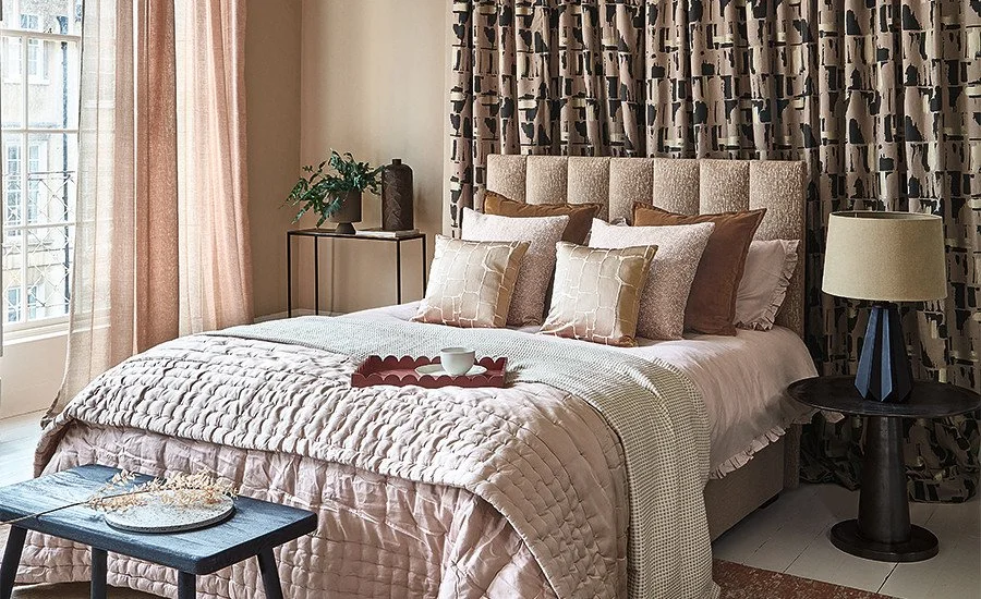 bedroom image with curtains and bedthrow and cushions
