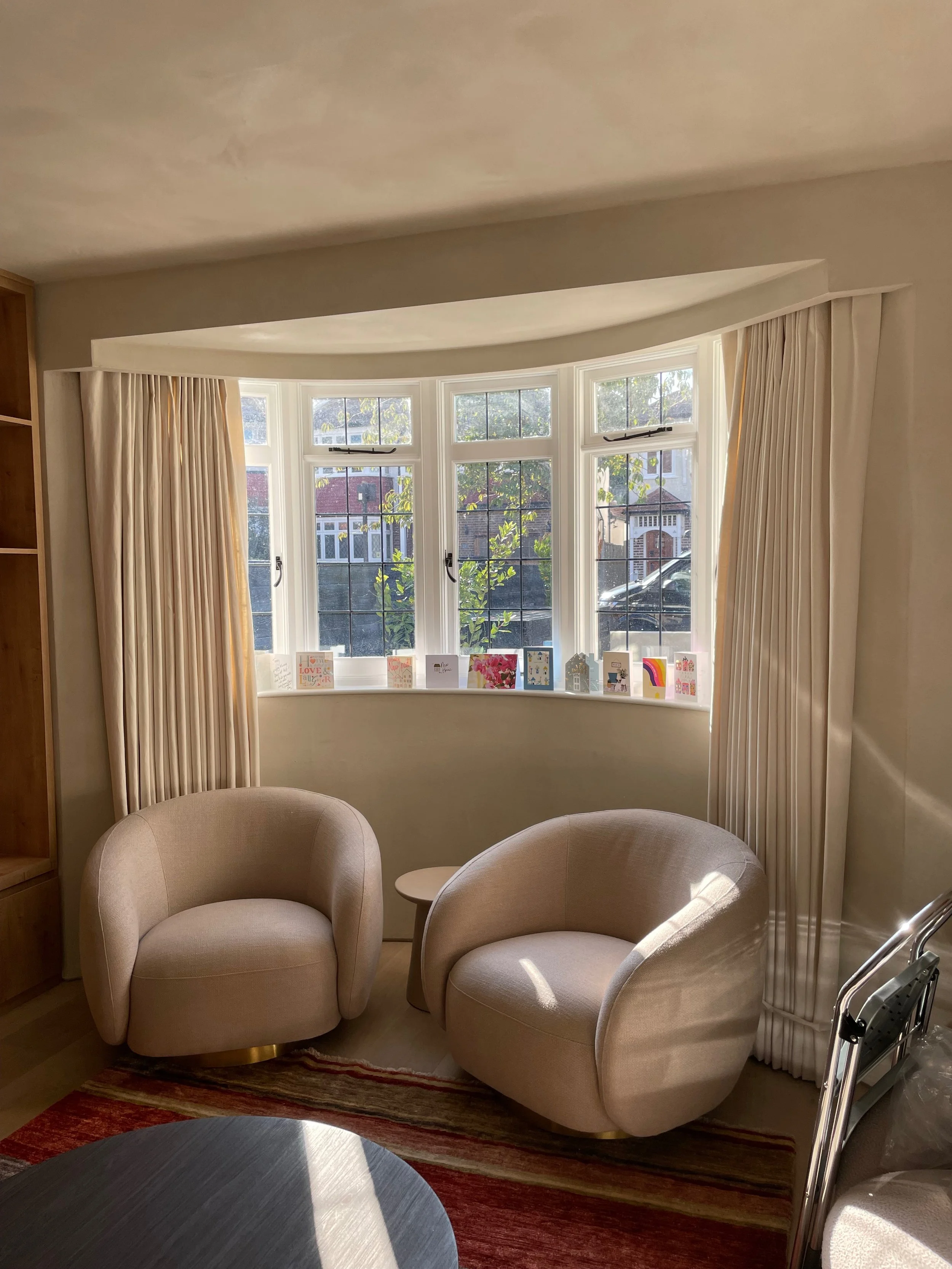 bay window with curtains and 2 chairs