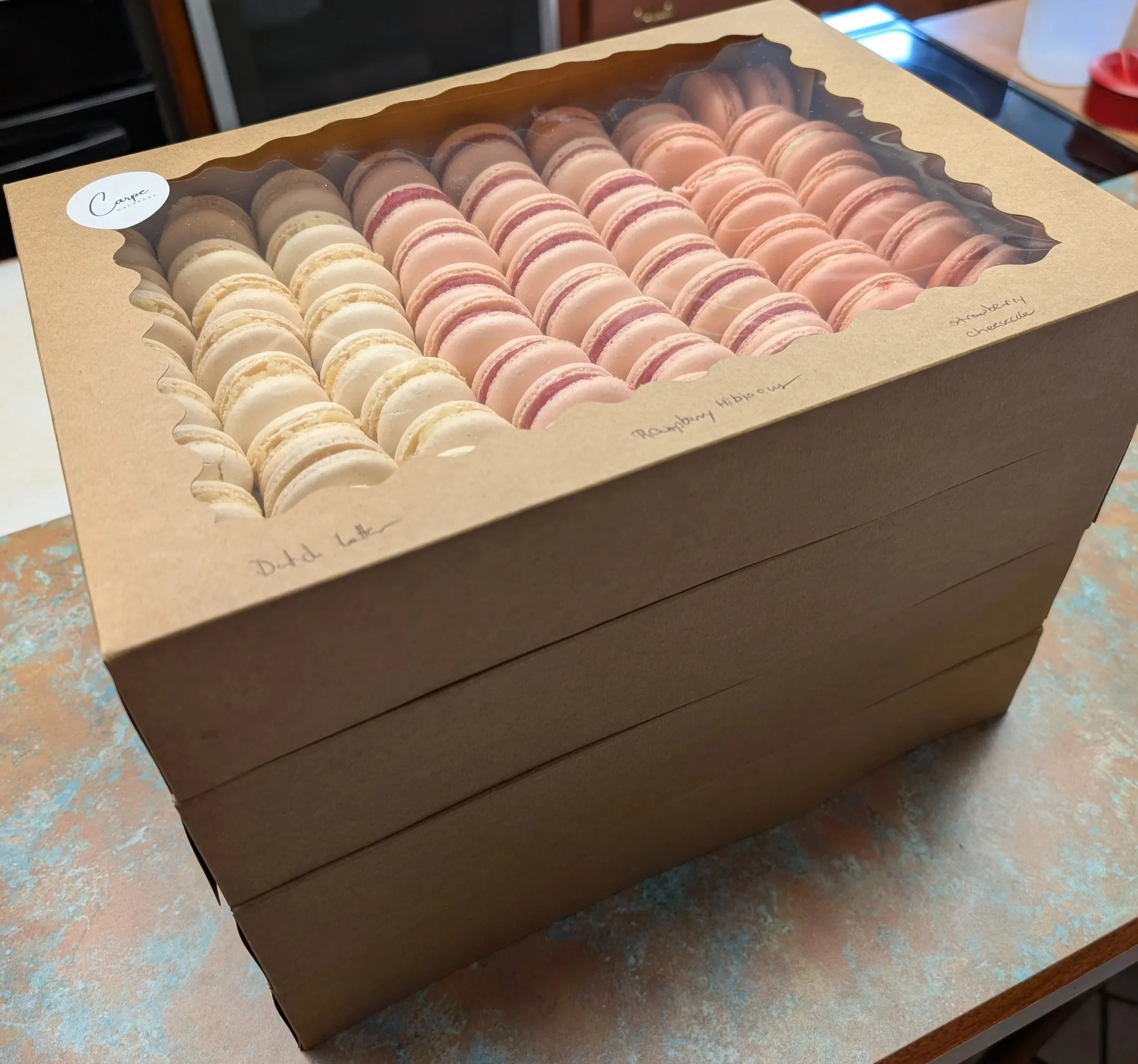 Bulk pacakges for graduation order, cream and pink colored macaarons, dutch letter and raspberry hibiscus flavors