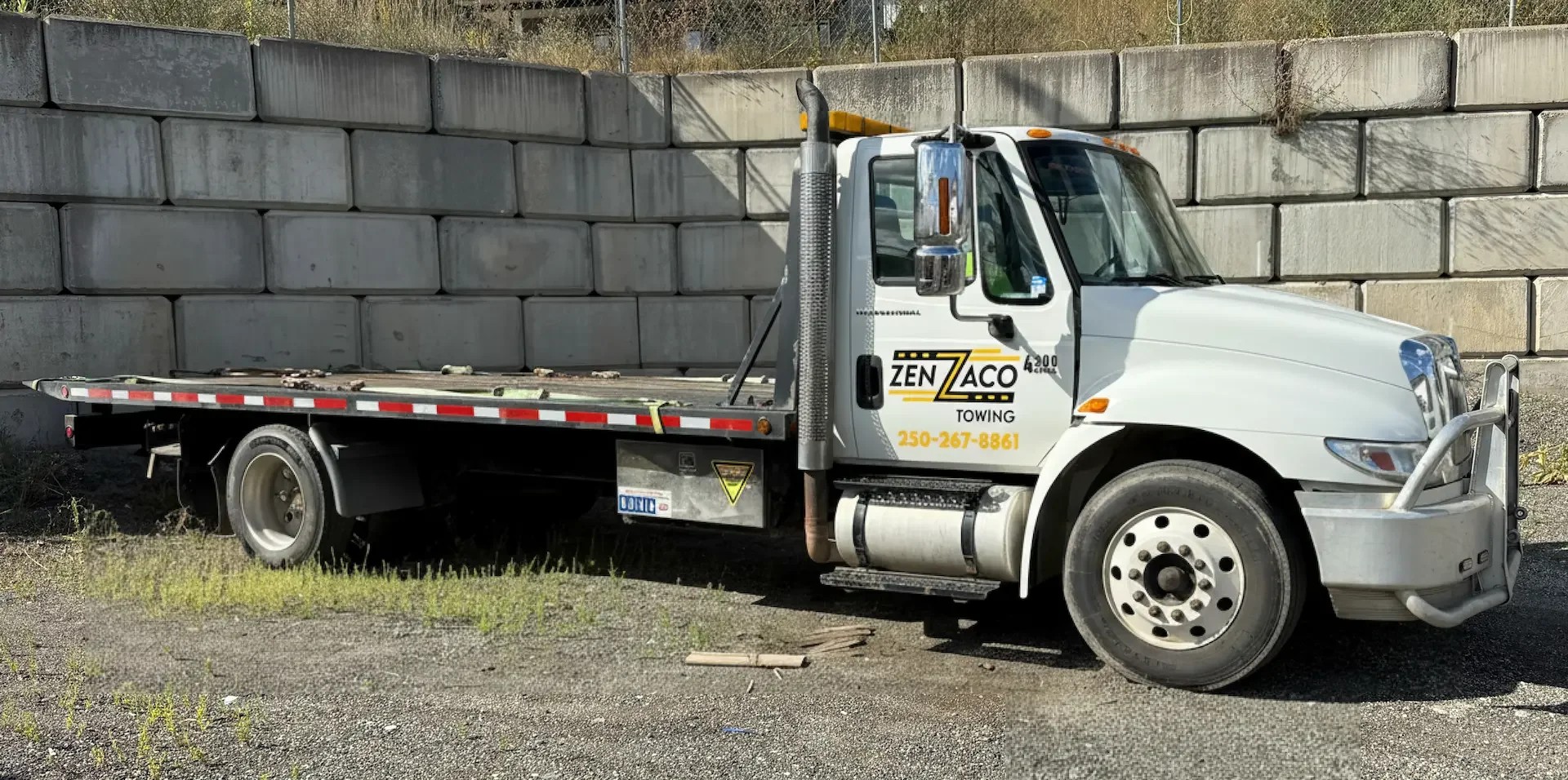 Zenzaco Towing's 21 foot, white deck truck.