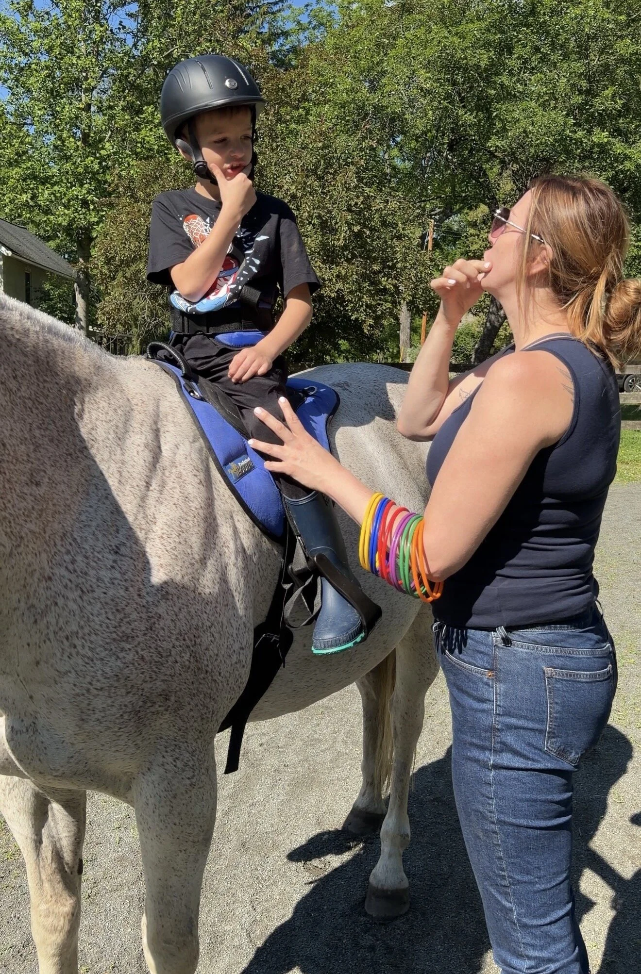 Dr. Jenn Moore providing speech therapy while a child rides a horse
