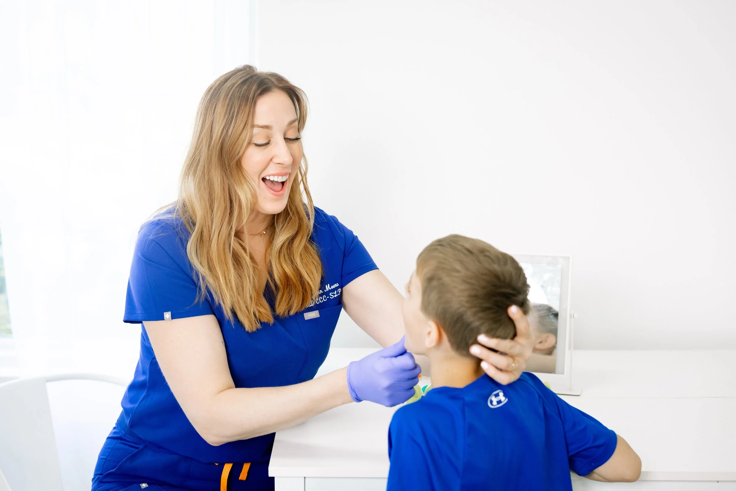 Dr. Jenn Moore providing PROMPT therapy to a child during a speech therapy session.
