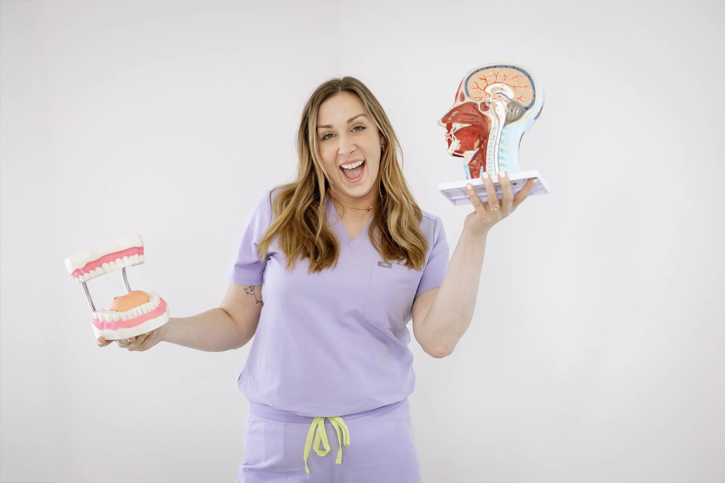 Dr. Jenn Moore holding anatomical models during a comprehensive speech, feeding, and myofunctional evaluation at Mouth Dynamics.