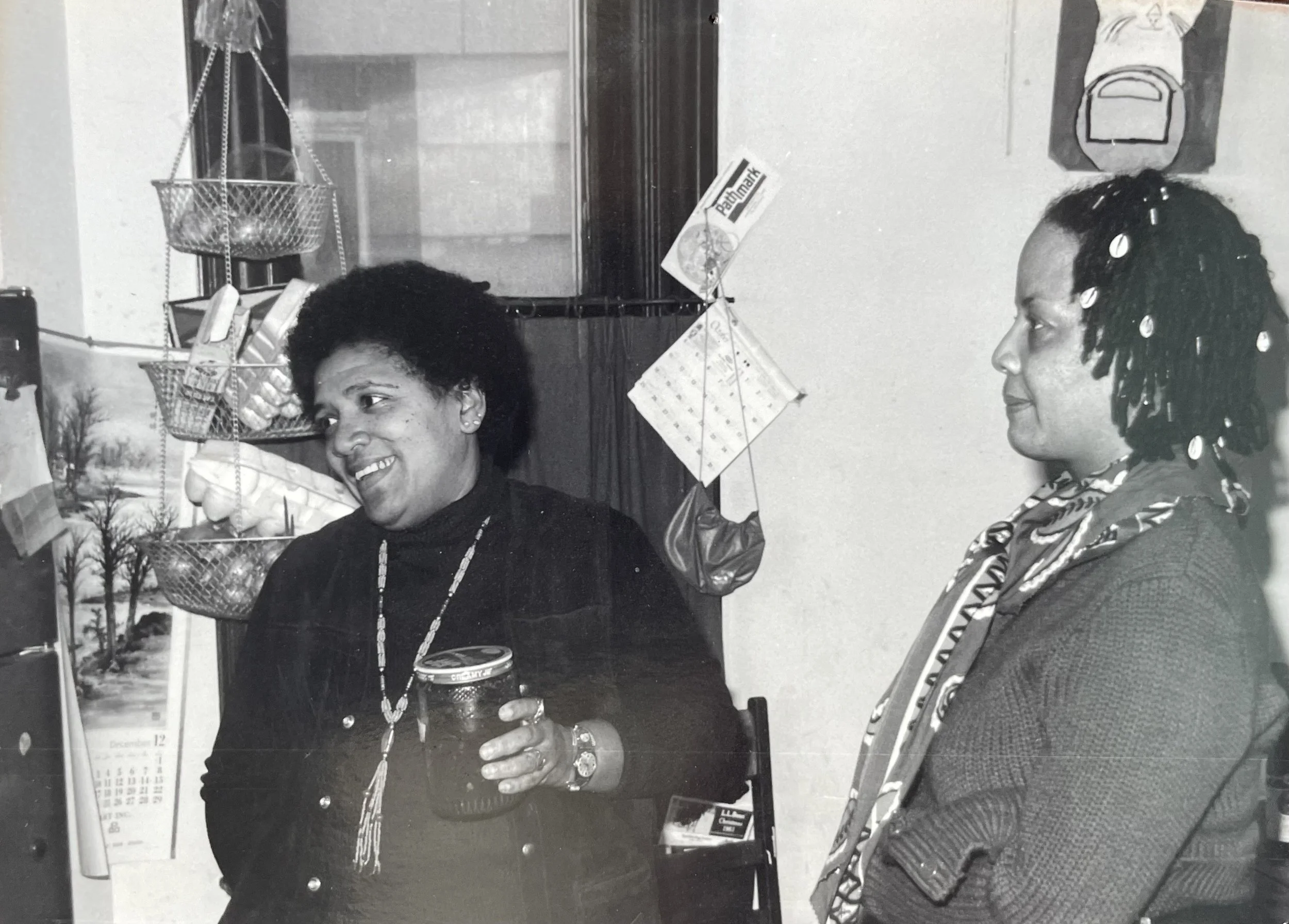 black and white picture of audre lorde, smiling, and hattie gossett in kitchen judith mcdaniel