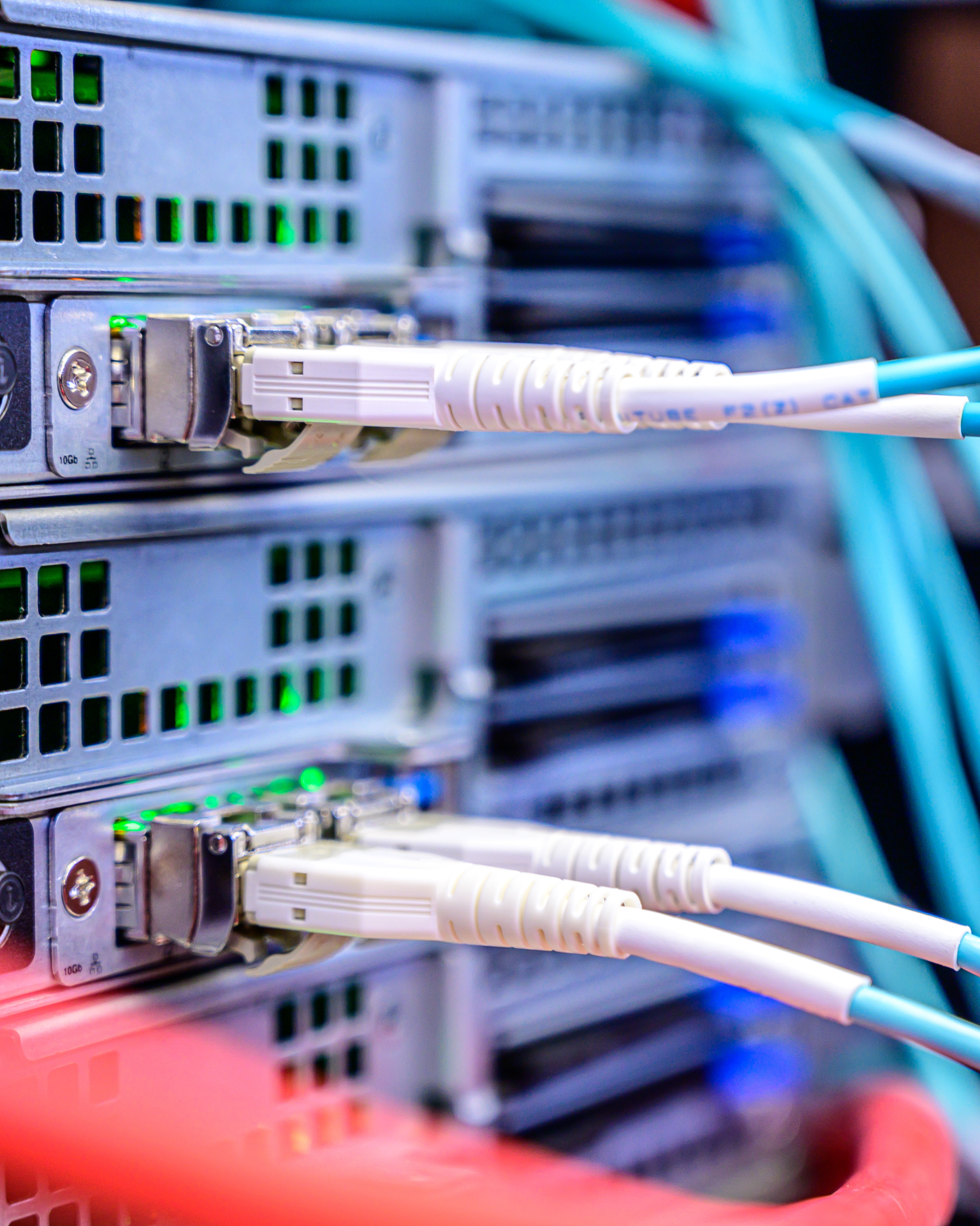 Close-up of Ethernet cables plugged into a network switch or server with green LED lights indicating active connections.