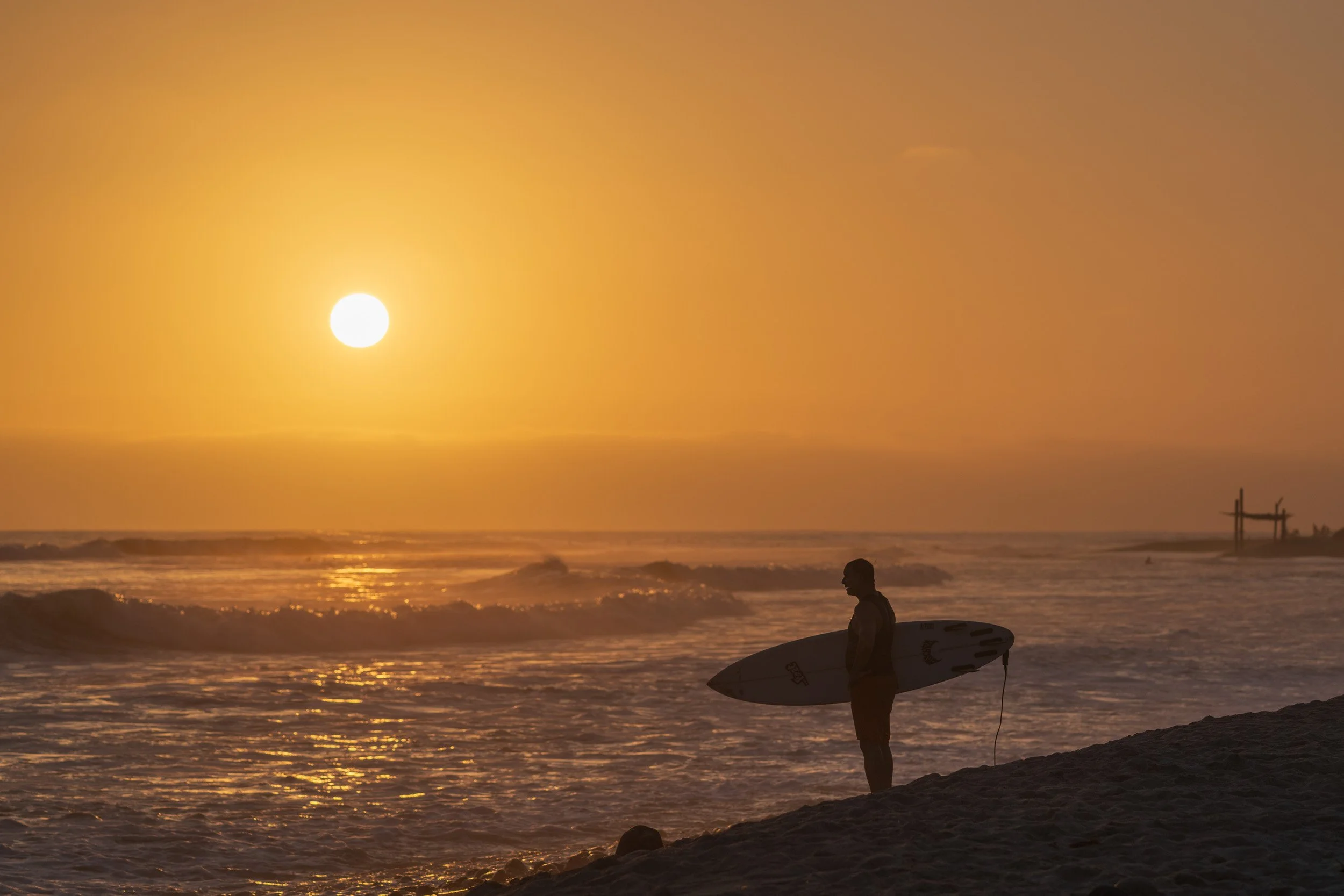 Silhouette of surfer at sunset 