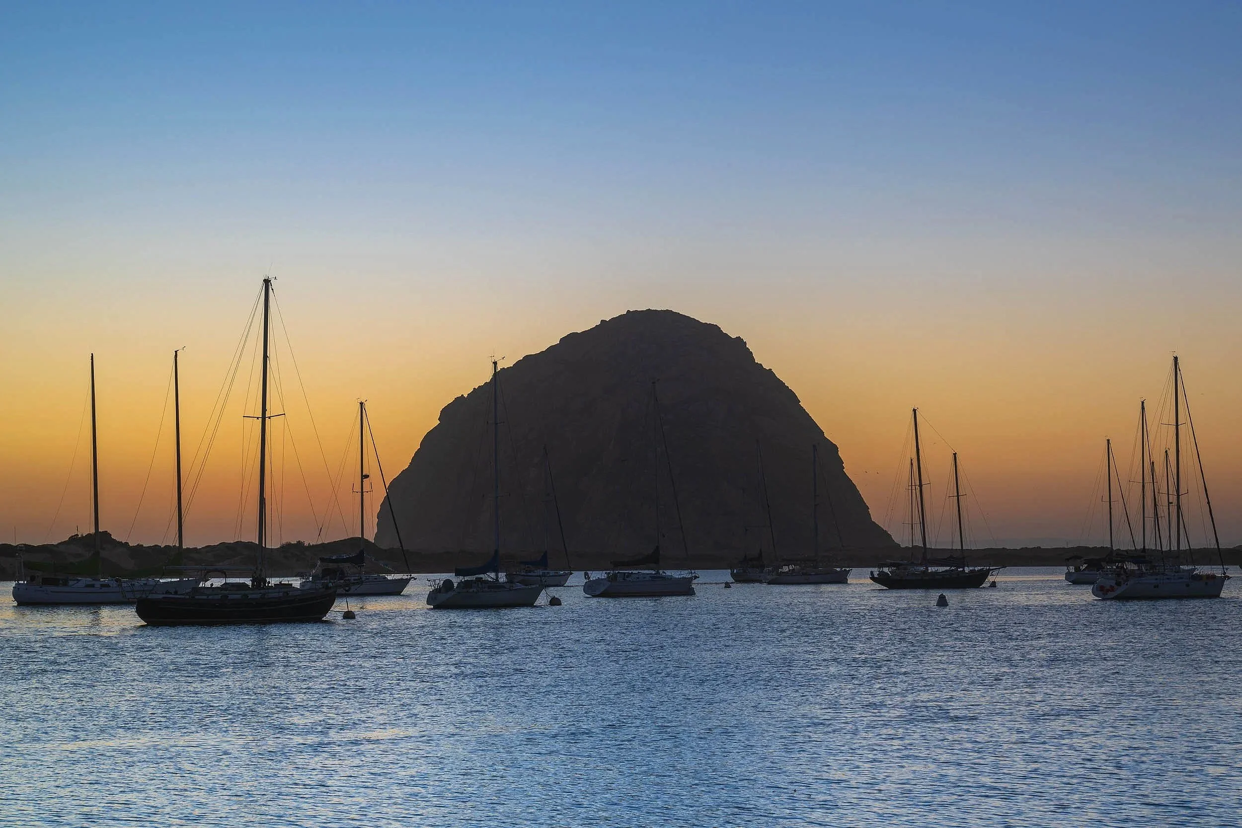 Silhouette of Morro Rock and sail boats in Morro Bay