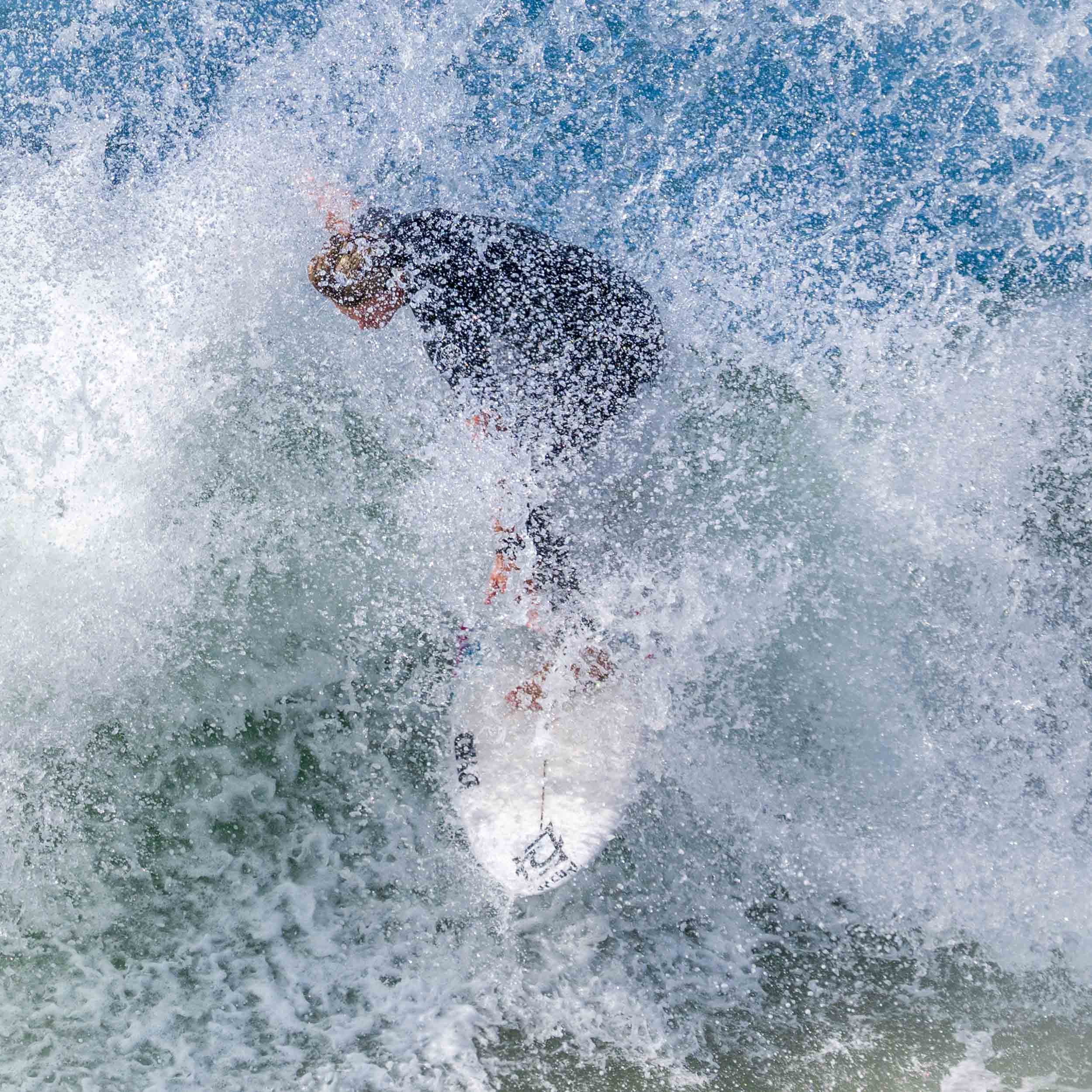 Surfer covered in wave