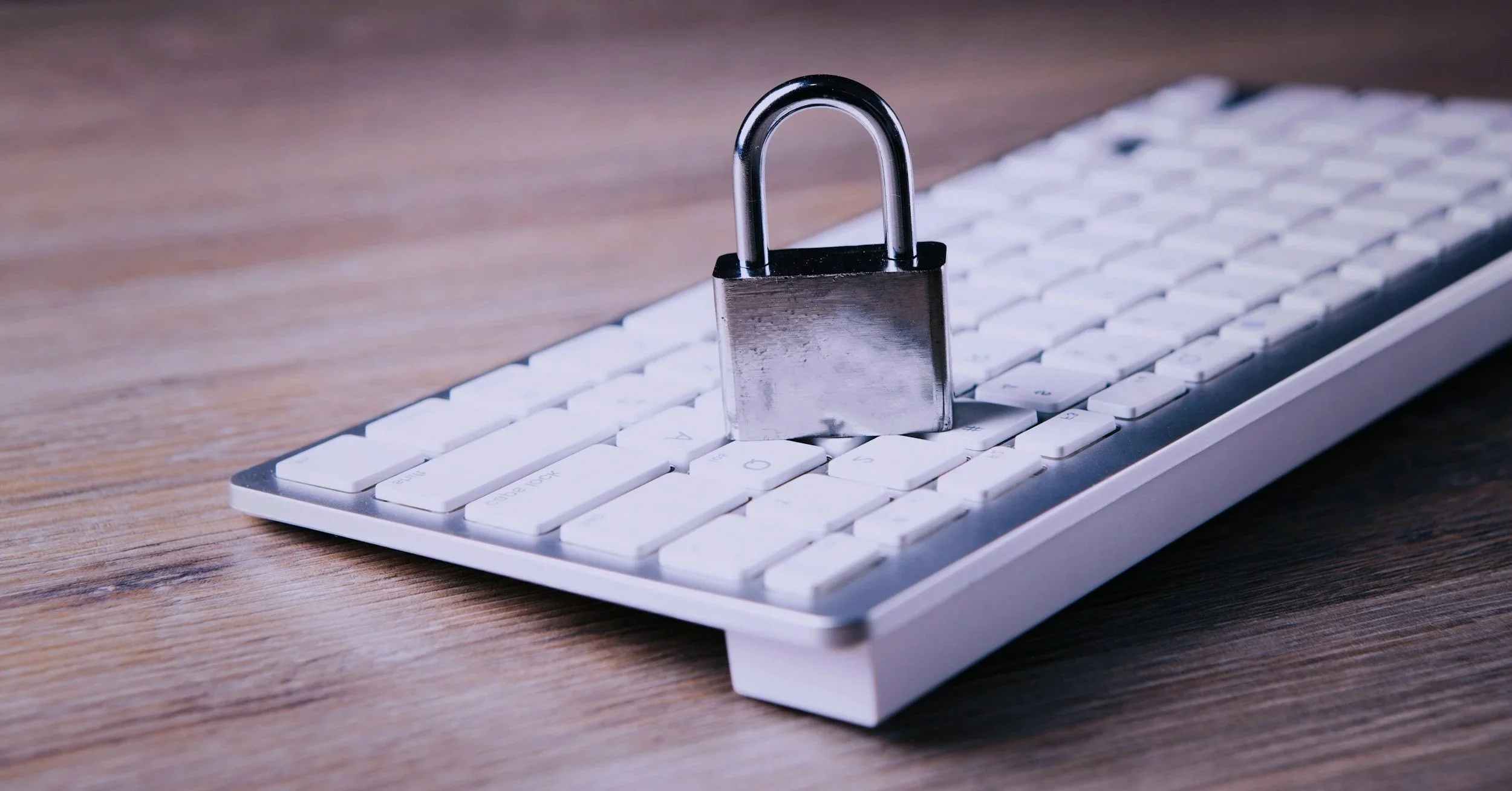 A computer keyboard with a padlock placed on top of the keys, symbolizing security or data protection.