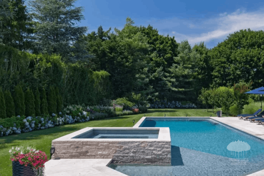 Pool and spa area bordered by tall evergreen trees for year-round privacy