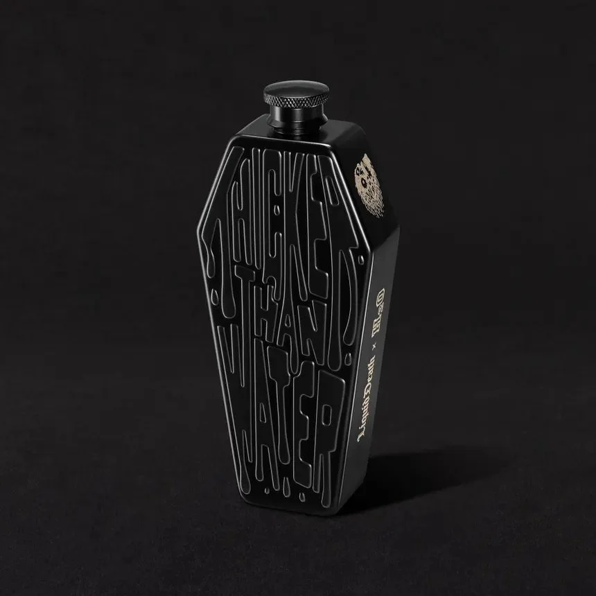 Black bottle with abstract text design, containing Jack Daniel's Tennessee Whiskey, against a black background.