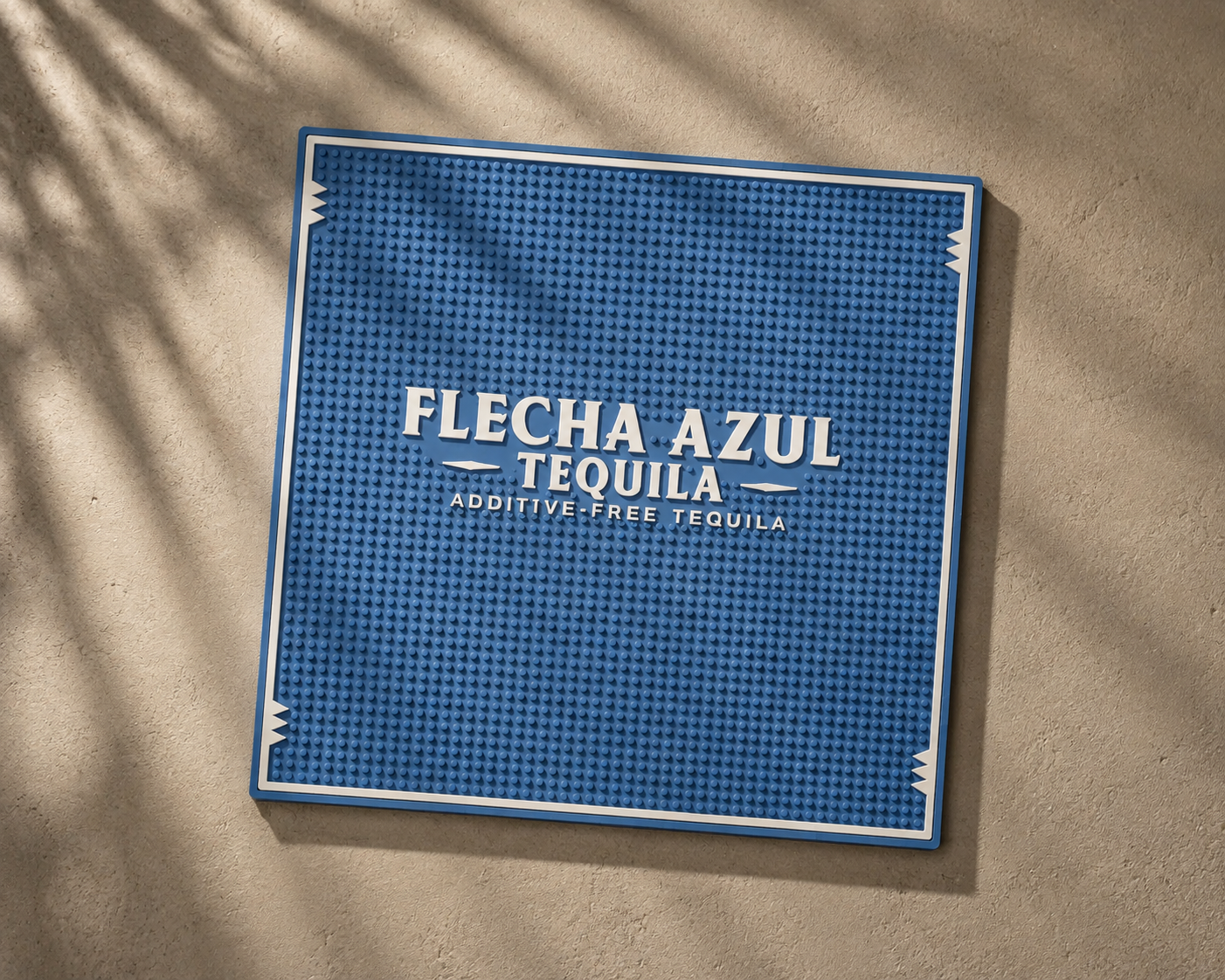 Blue sign with white text reading 'Flecha Azul Tequila Additive-Free Tequila' on a beige wall.