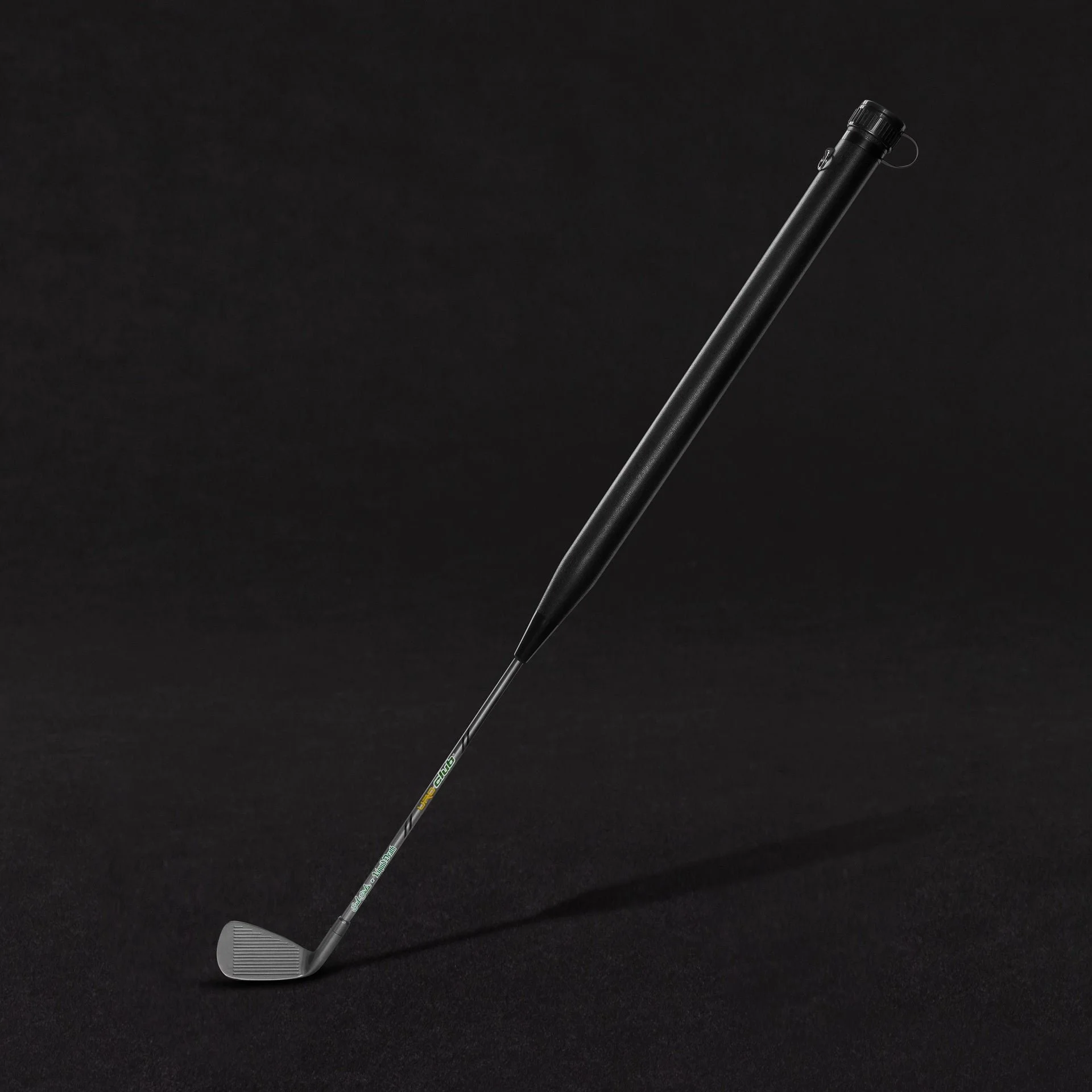 Golf club with a black grip and a silver clubhead on a black background.
